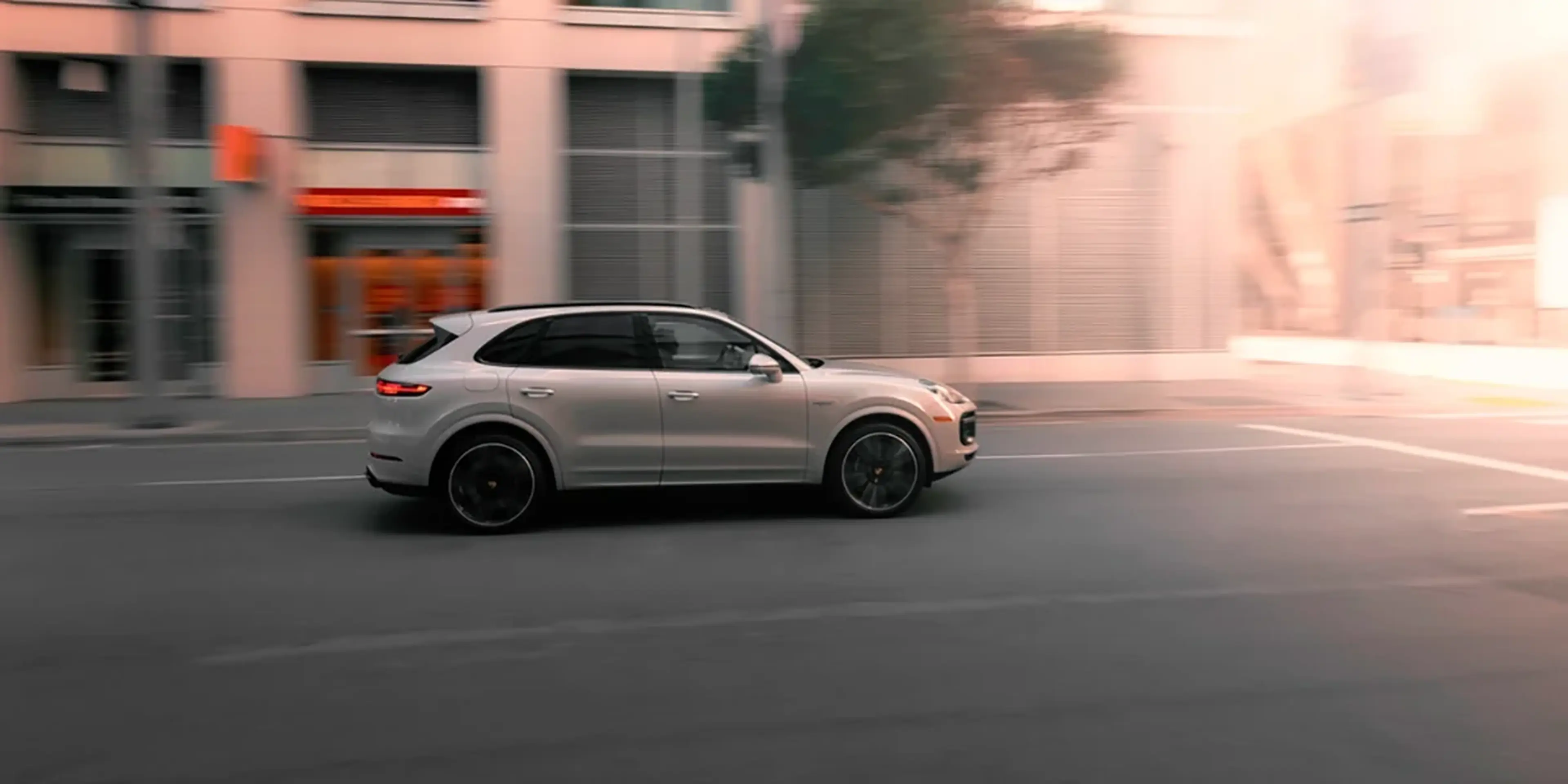 Silver Porsche Cayenne driving on a city street
