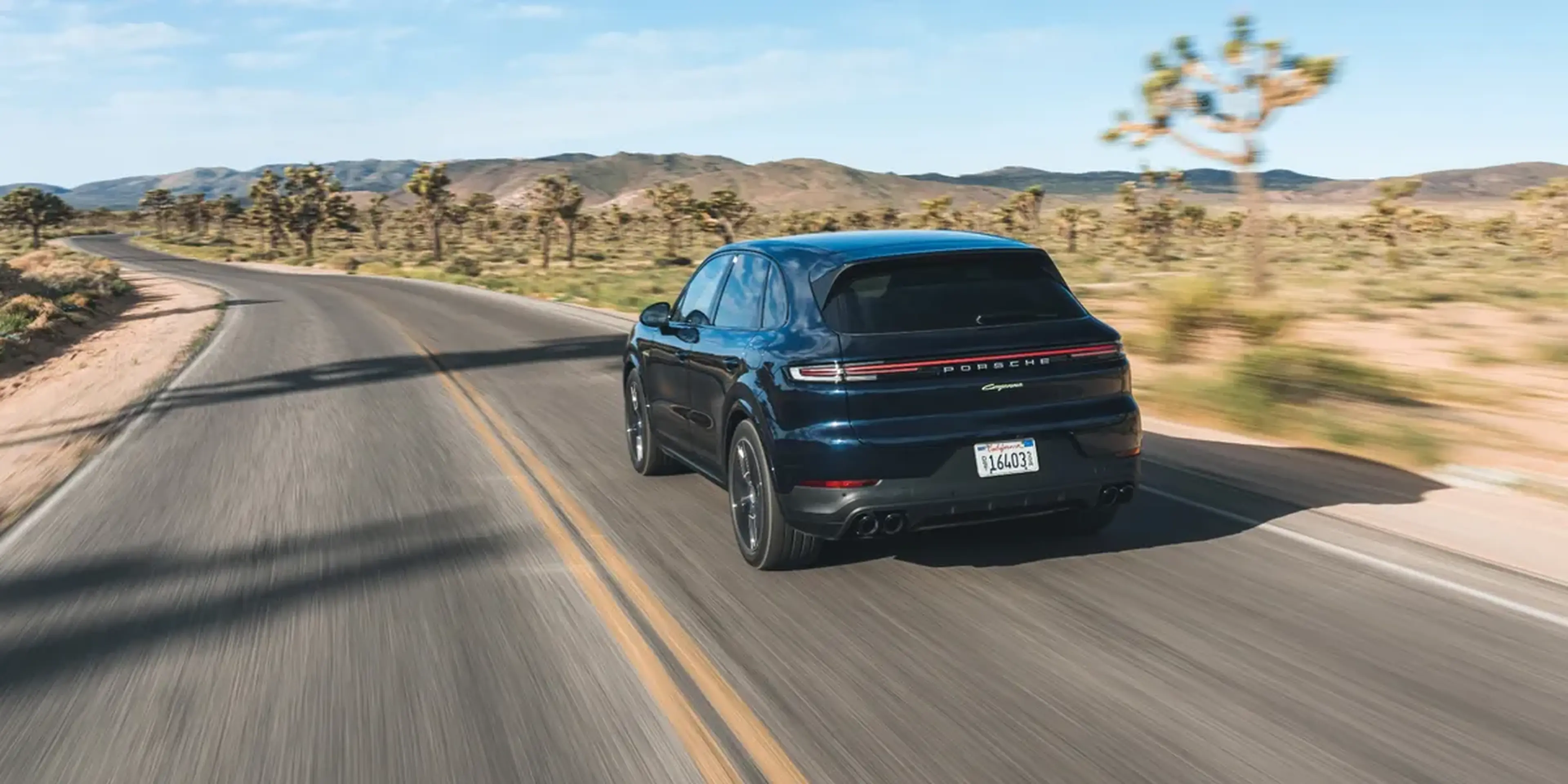 2026 Porsche Cayenne driving on a scenic mountain road