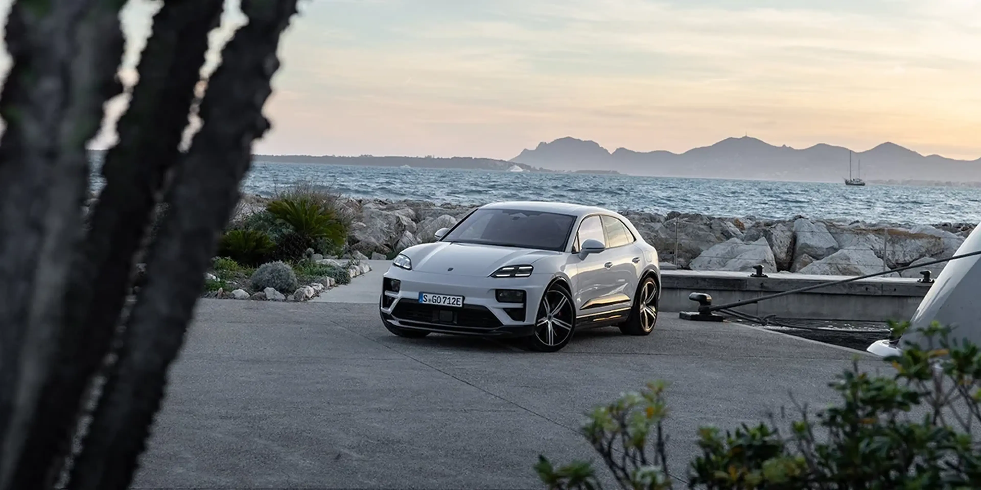 Silver 2025 Porsche Macan Turbo Electric by the water