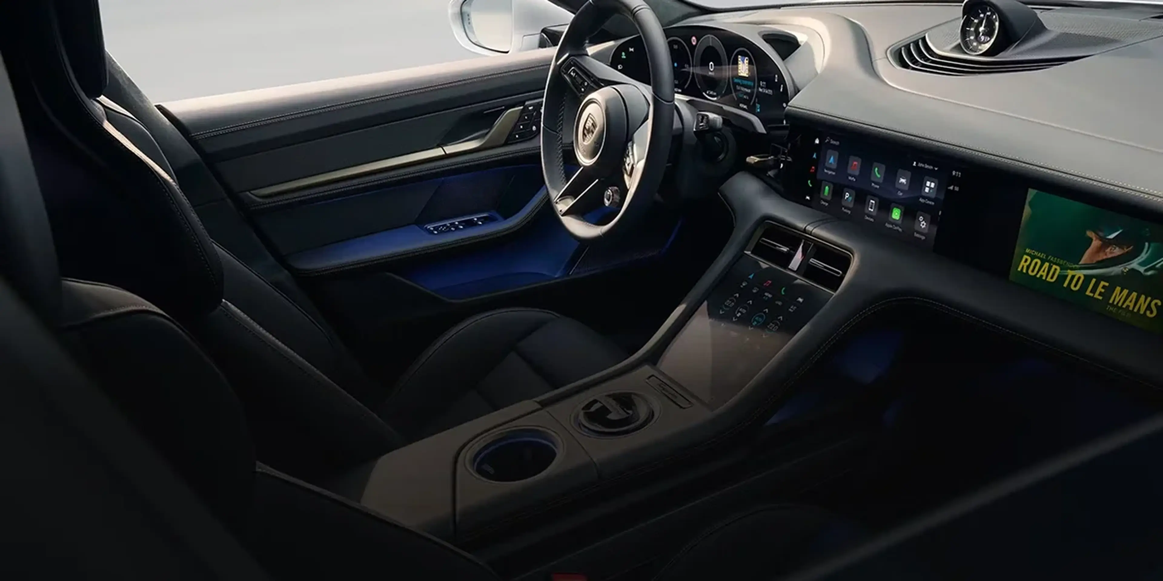 Porsche Taycan driving along a winding coastal road, showcasing balanced handling and electric agility.