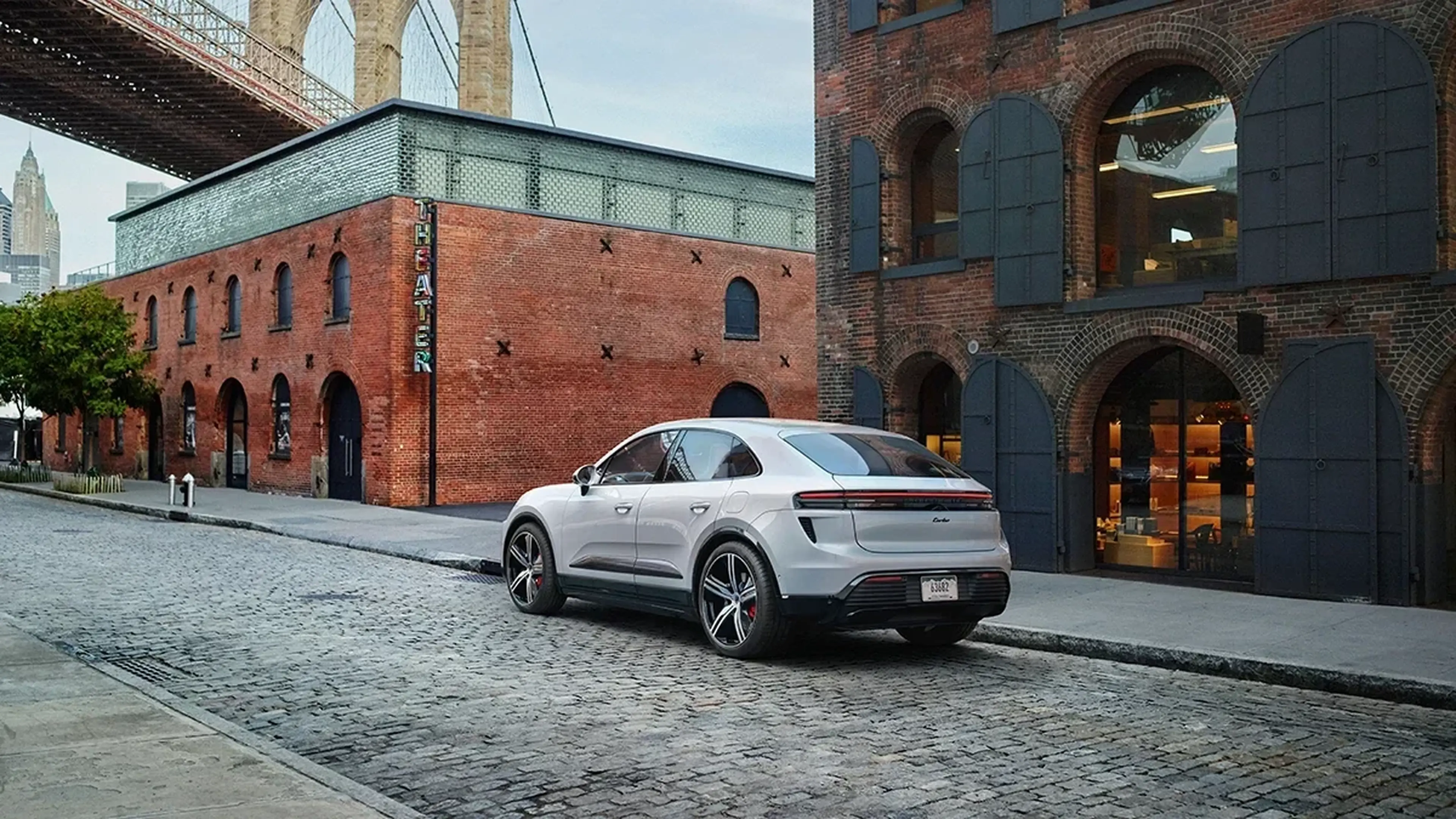 Porsche Macan Electric parked by a brick building