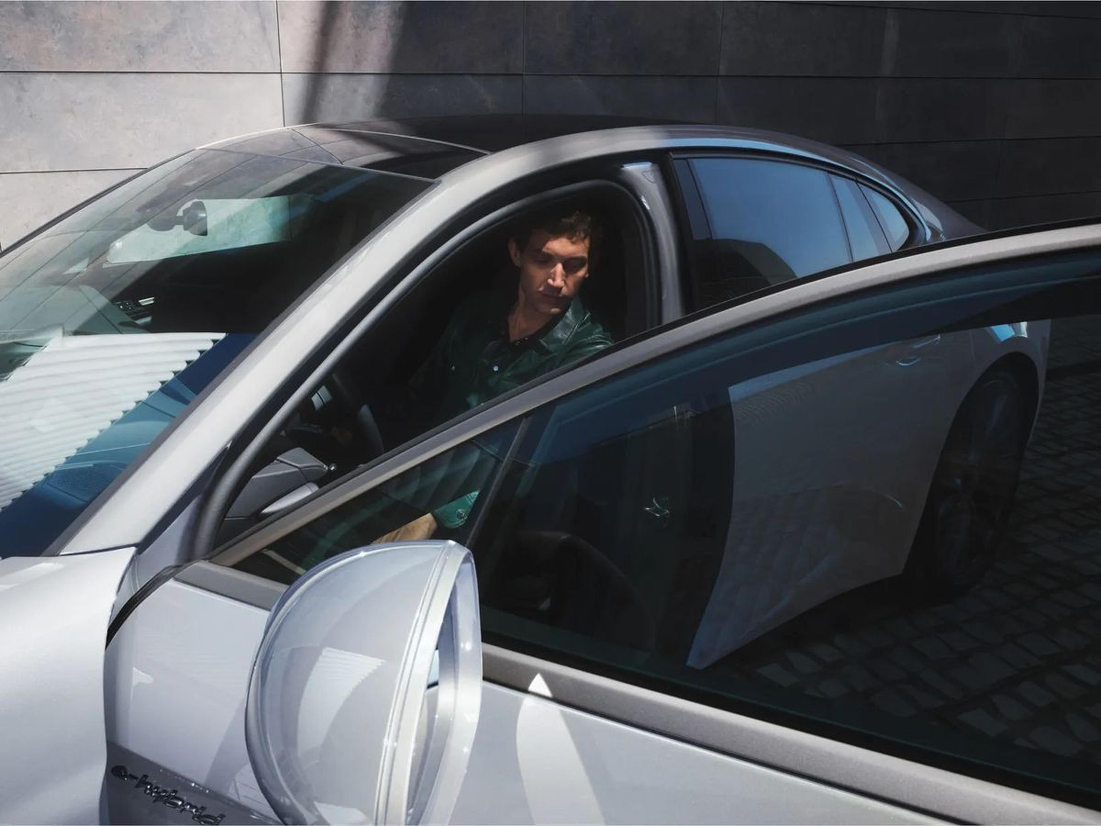 Person entering a 2026 Porsche Panamera E-Hybrid, e-hybrid badge visible on the side mirror