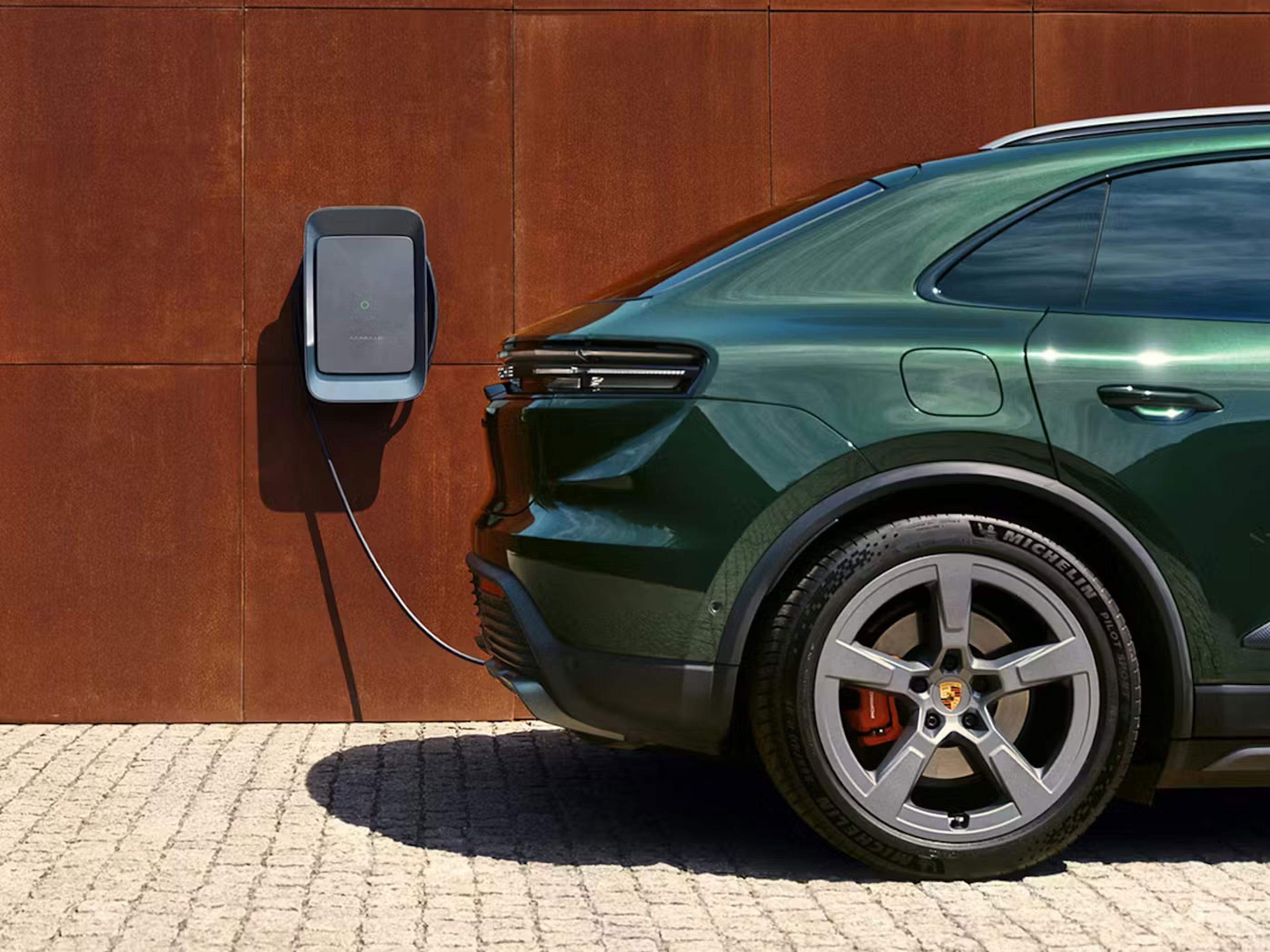 Heck eines grünen Porsche Cayenne Electric der an einer Wallbox angeschlossen ist.