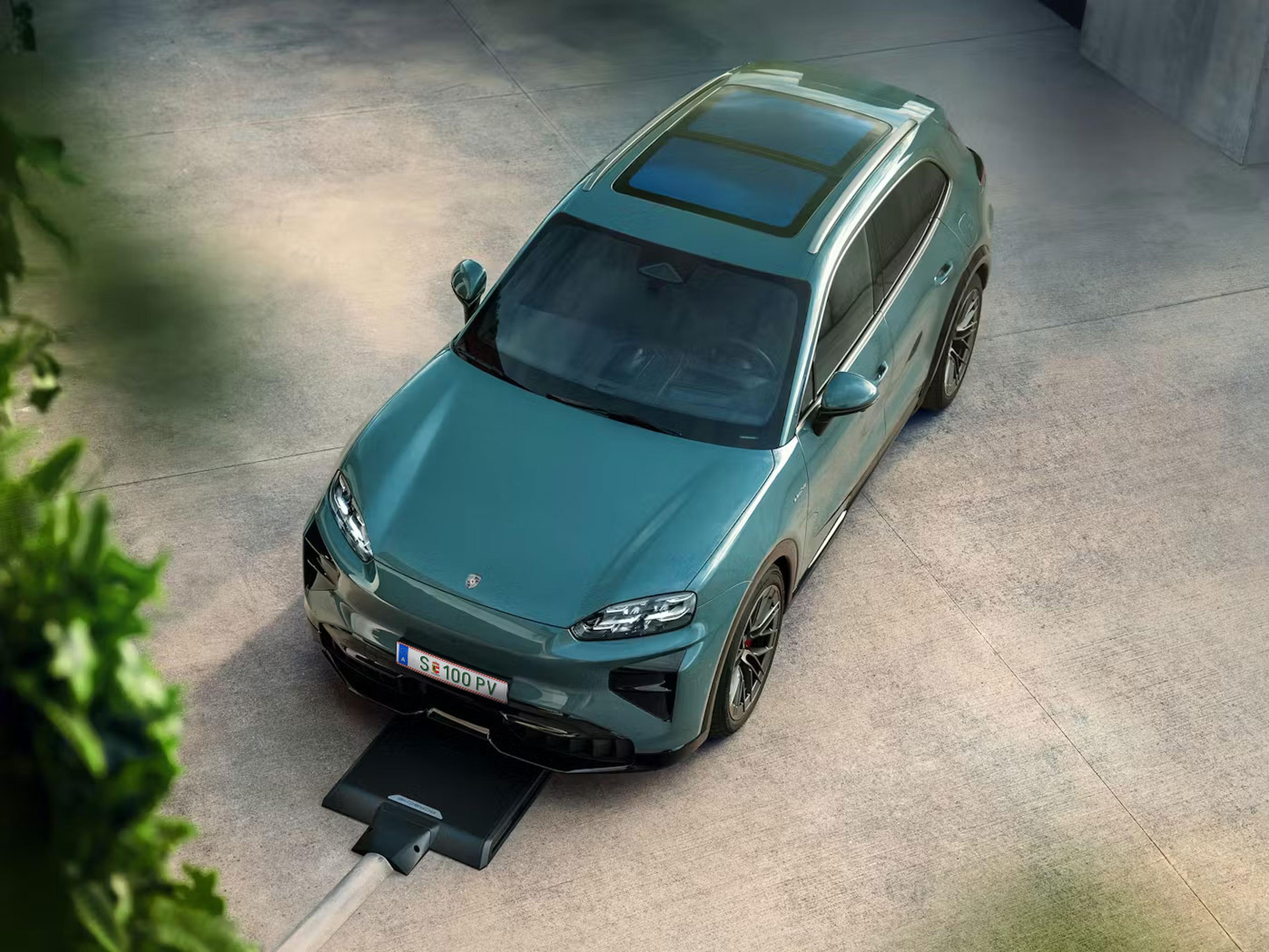 Ein grüner Porsche Cayenne Electric , der auf einer Betonfläche geparkt ist und Via Induktion geladen wird.