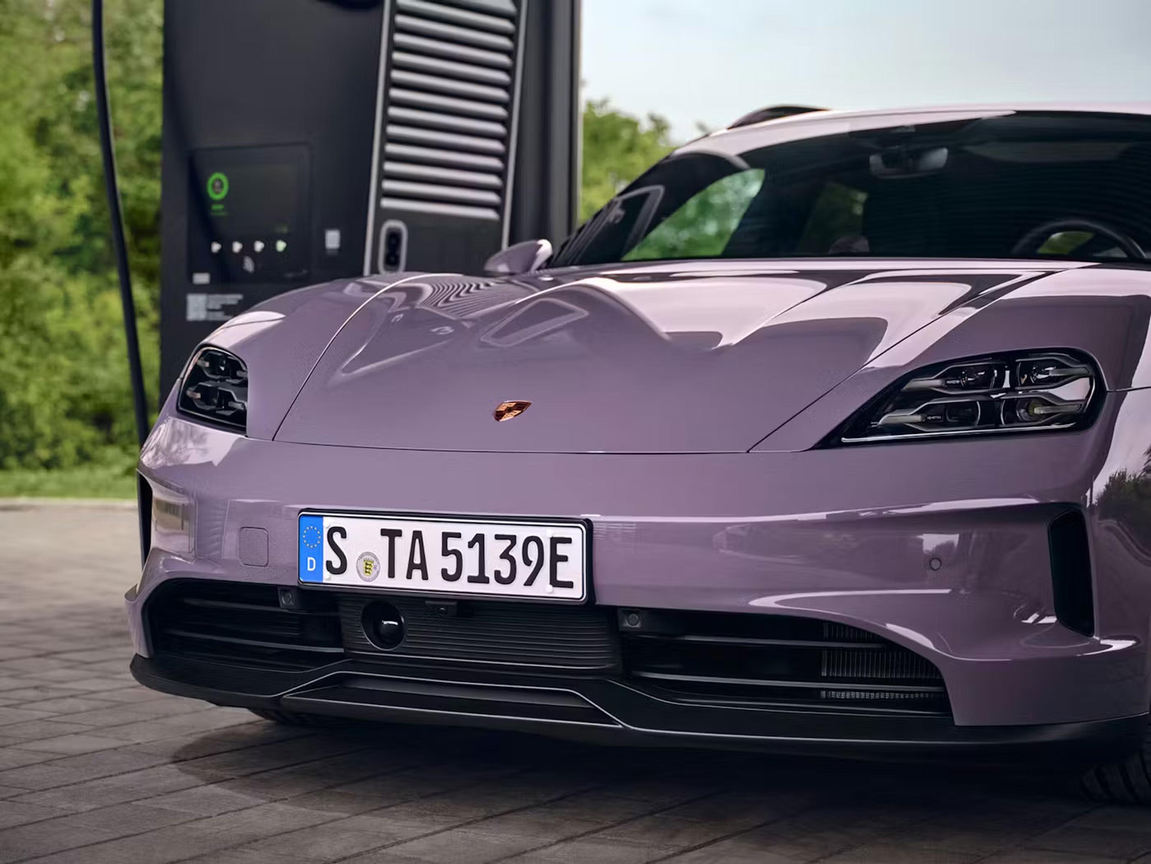 Ein violetter Sportwagen mit eleganten Designmerkmalen und modernen Scheinwerfern steht an einer Elektro-Ladestation.