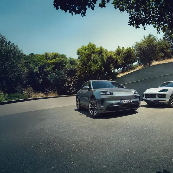 Three Porsche Cayenne vehicles parked on a wooded road