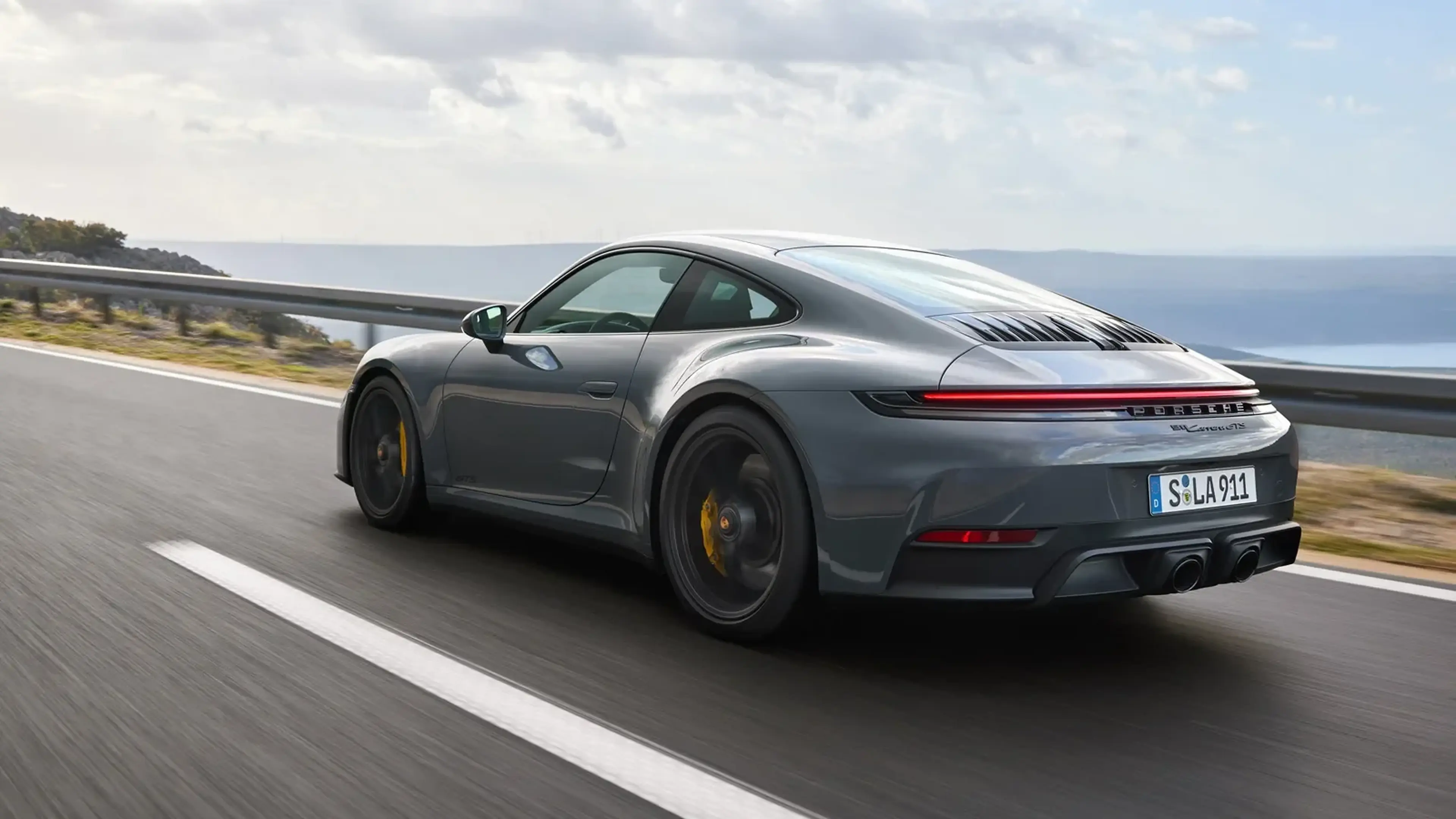 Gray 2025 Porsche 911 Carrera GTS driving