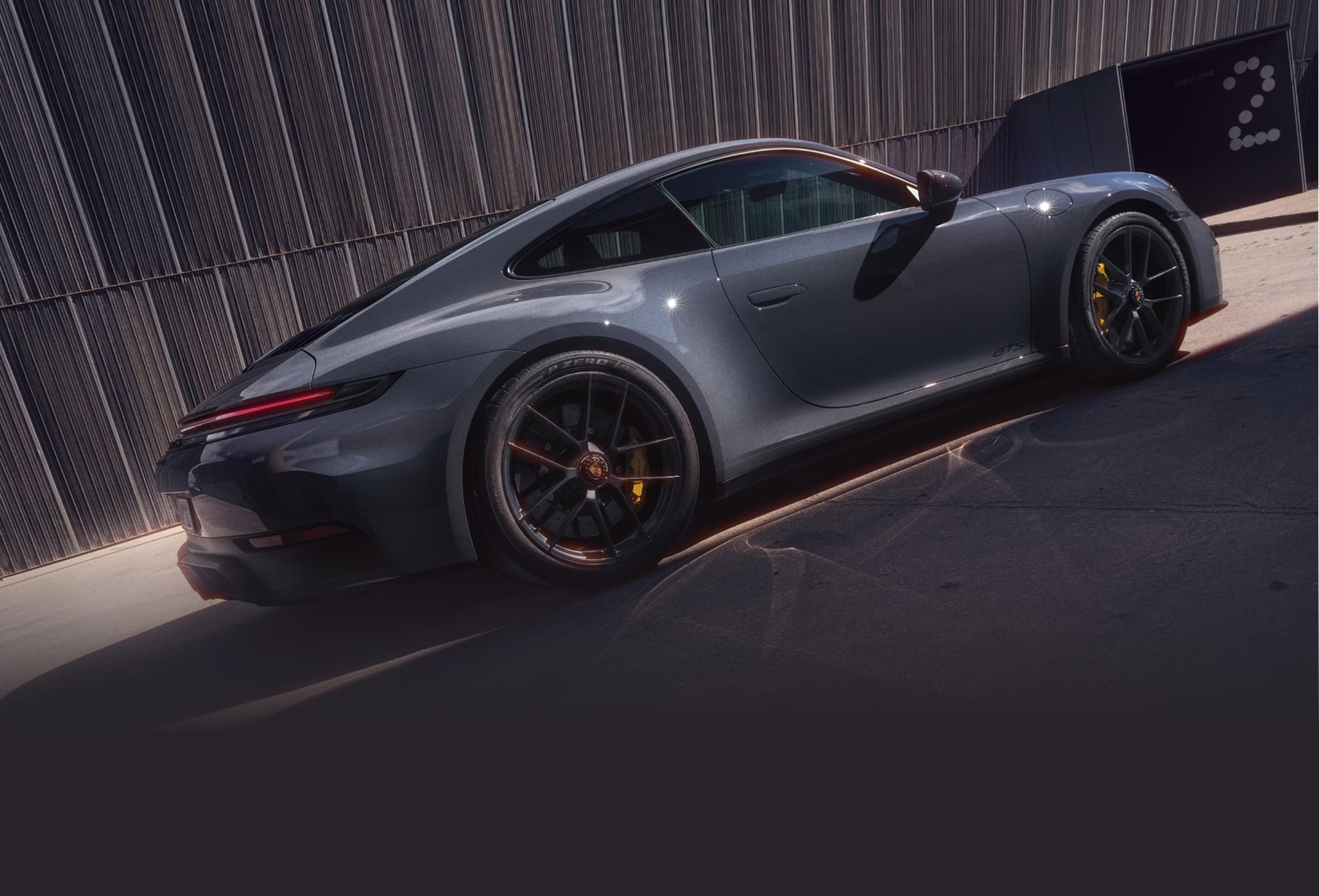 Gray 2027 Porsche 911 Carrera S with MT Package parked beside a modern building
