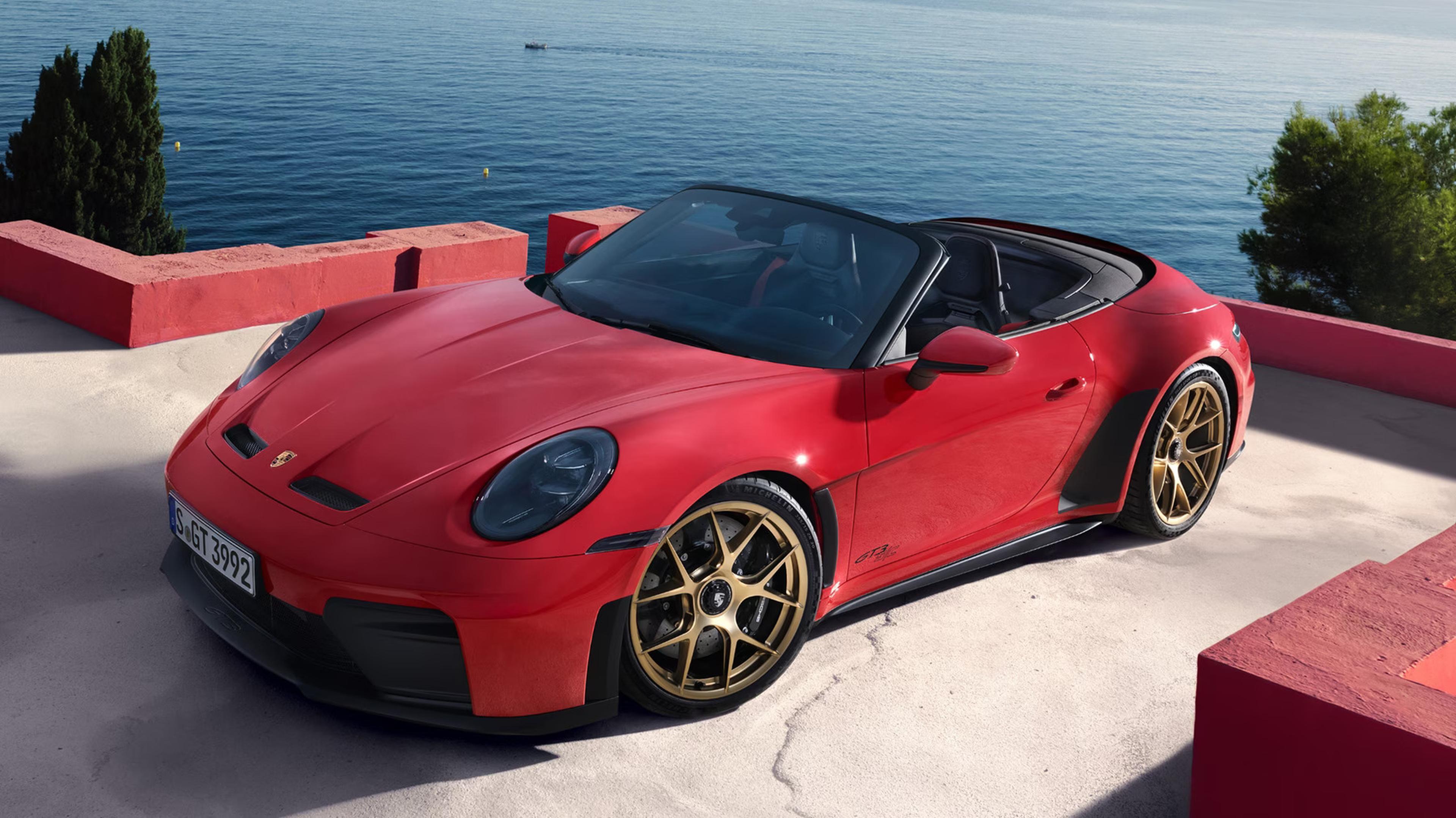 2027 Porsche 911 GT3 S/C open-air performance convertible in red with gold wheels near the ocean