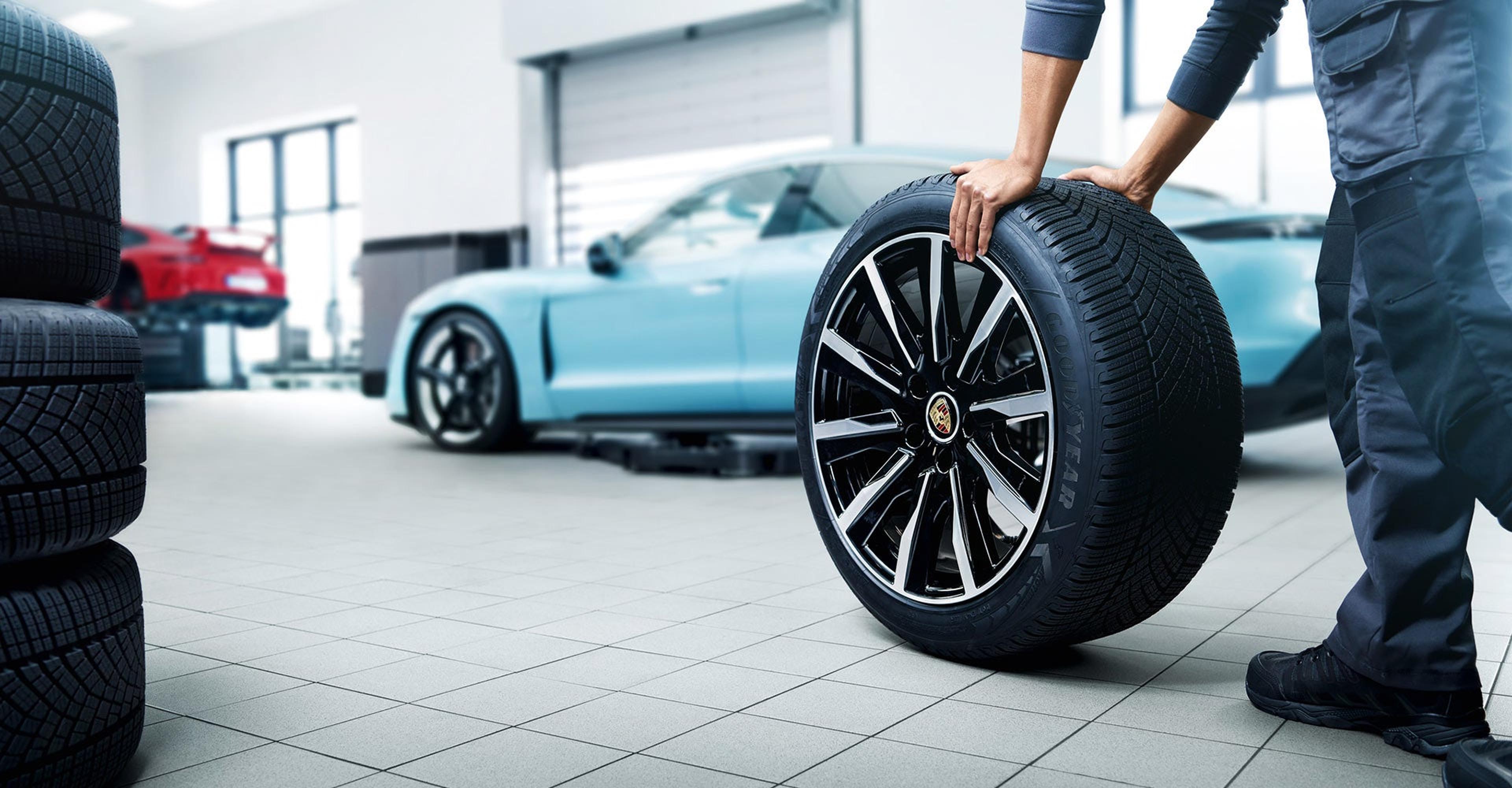 Technician inspecting a Porsche Taycan wheel