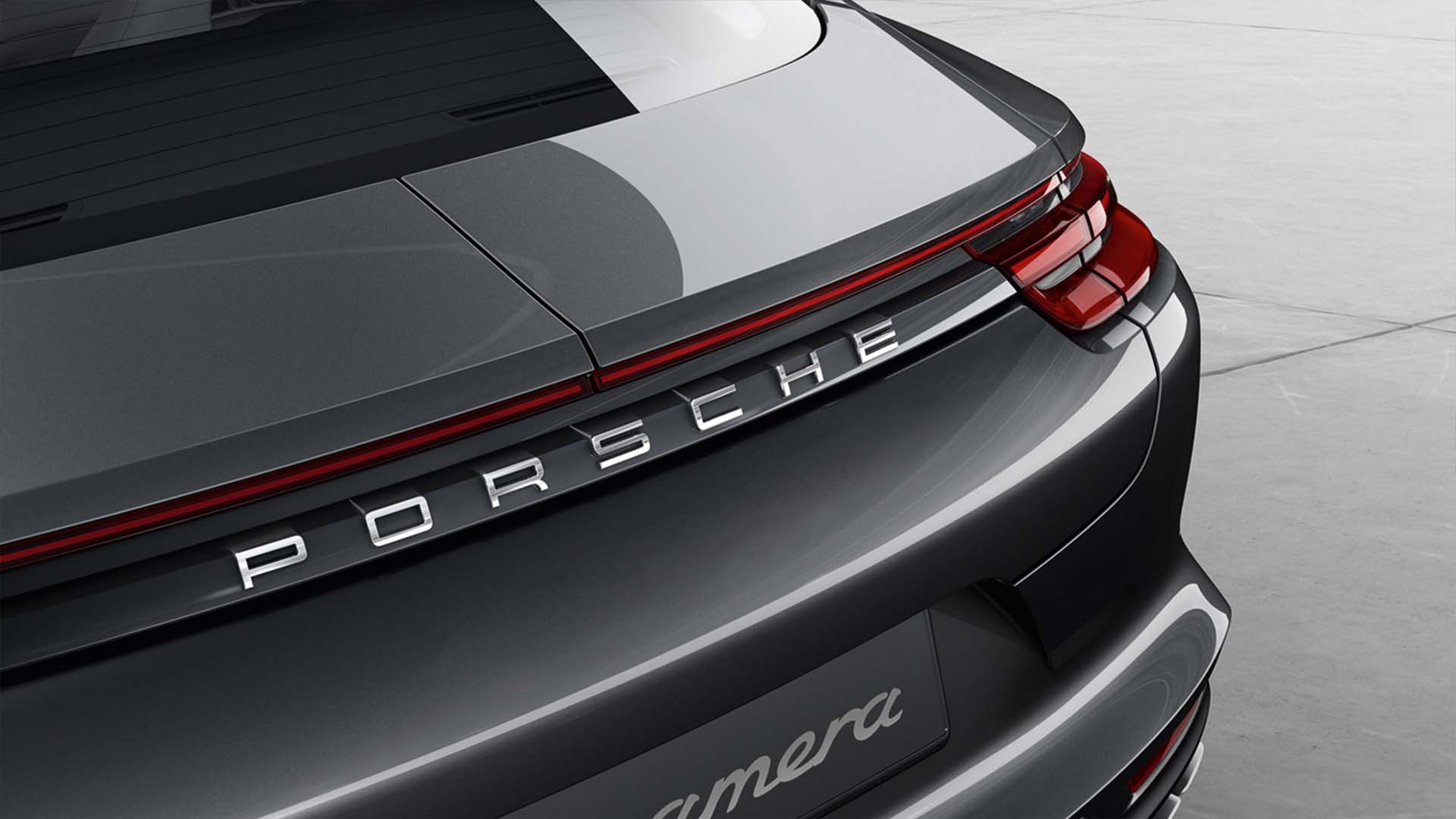 Panamera rear Close-up of the rear of a dark gray luxury car with a red taillight and the brand name "Porsche" displayed prominently.