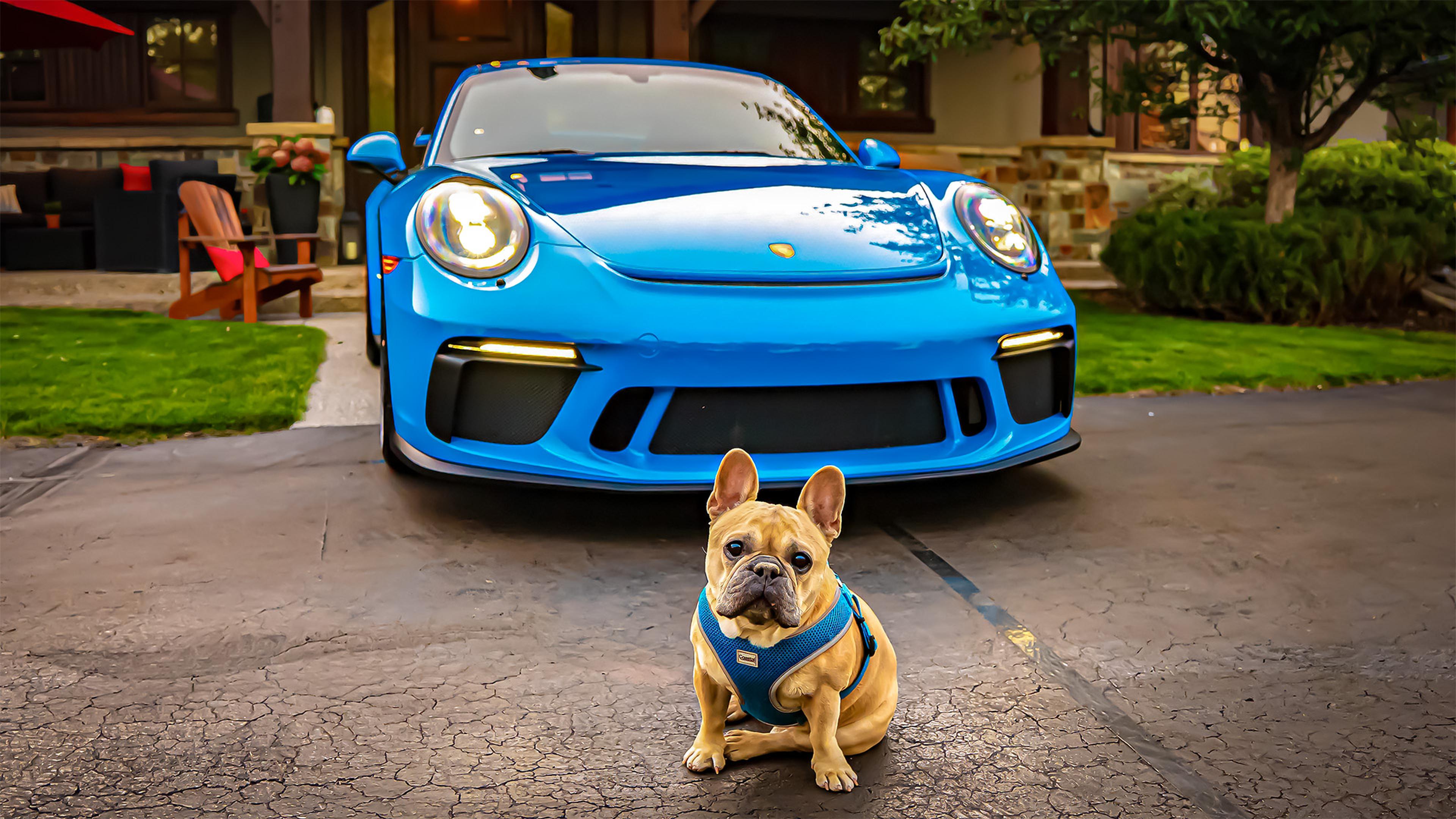 2018 Porsche 911 GT3 in Mexico Blue parked in front of a large house with wooden garage doors, sunlight reflecting off the car's hood.