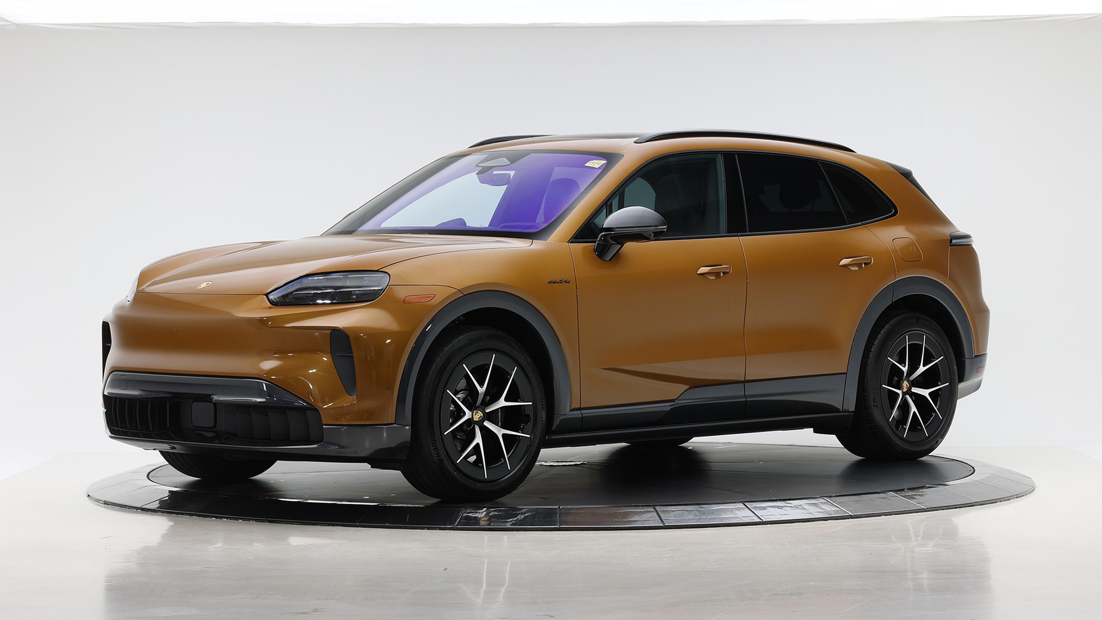 2026 Porsche Cayenne Electric Gold SUV with black accents and modern design on display in a well-lit studio.