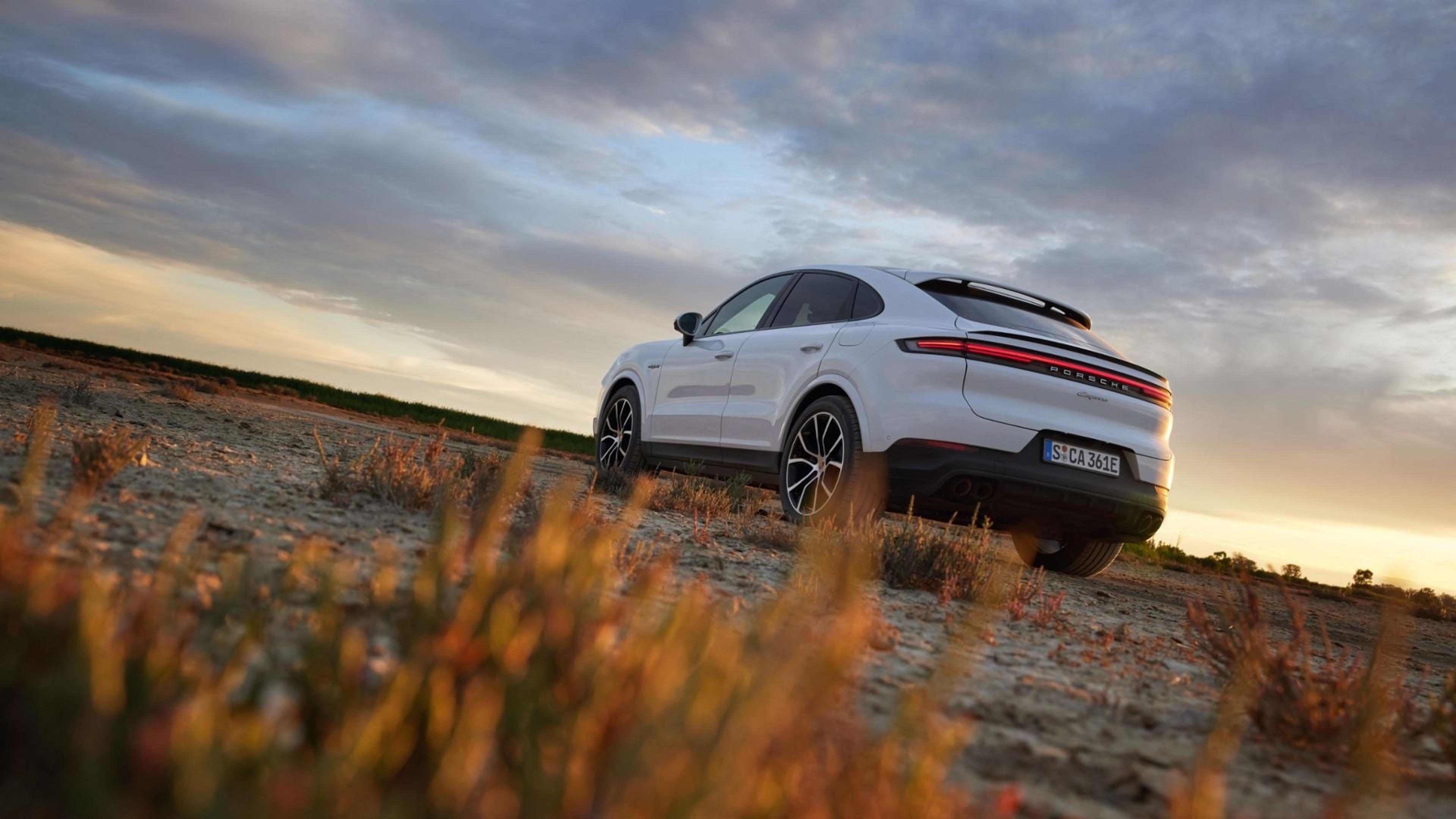 White Porsche Cayenne Coupe on a mountain road at dusk