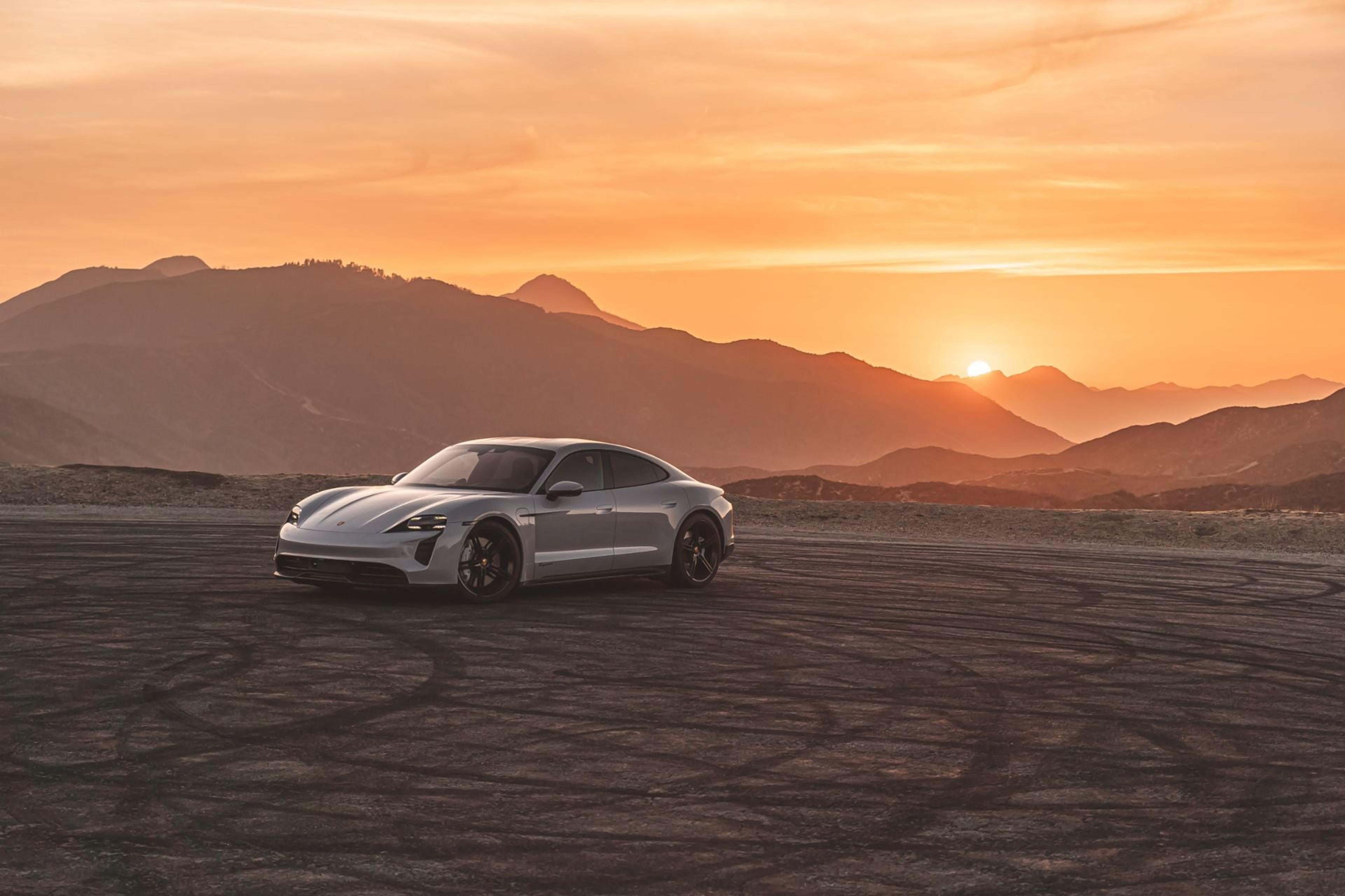 Porsche driving on a mountain road at sunset