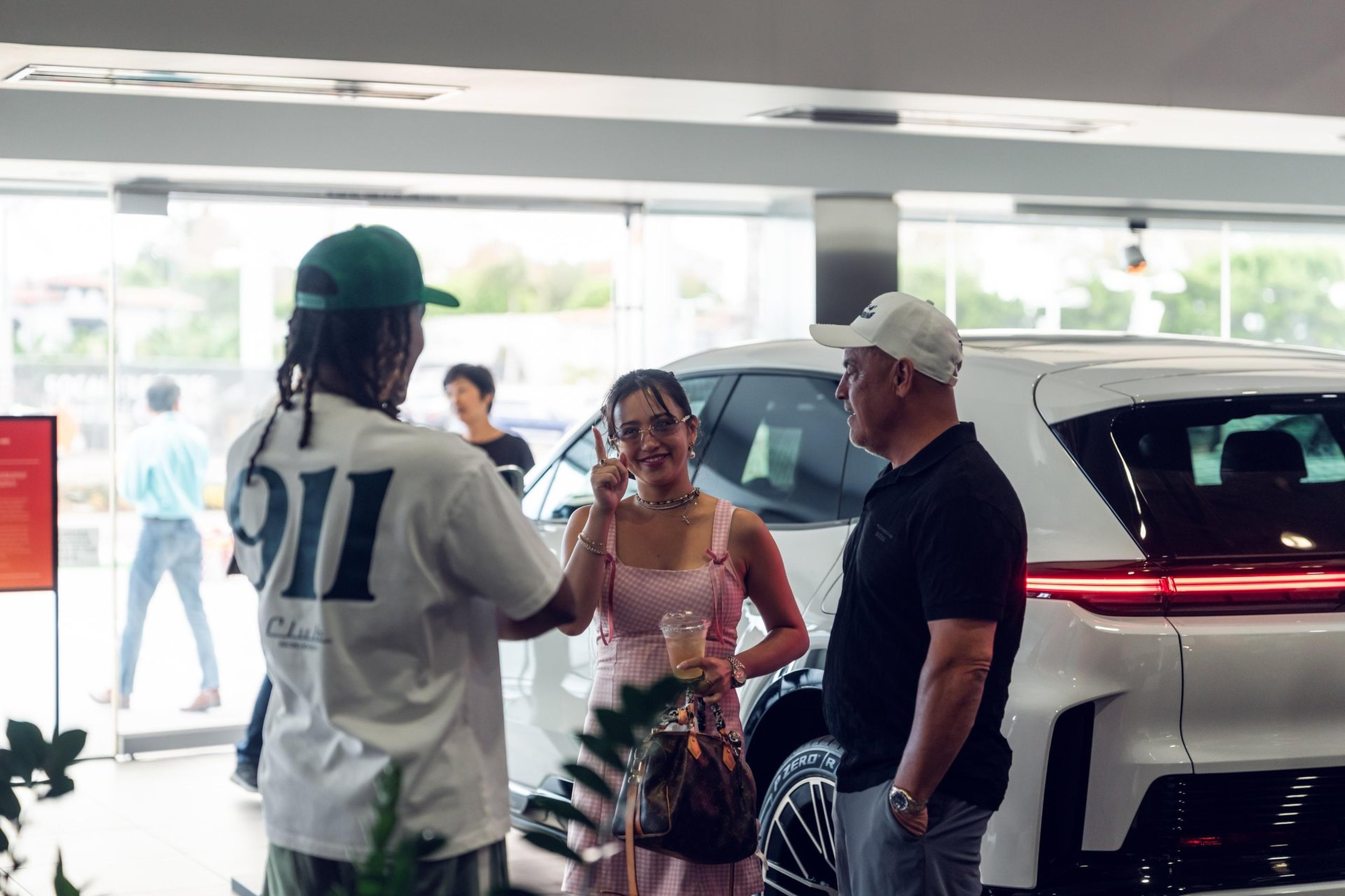 Guests gather beside the new white Porsche Cayenne Electric at McKenna Porsche in Norwalk