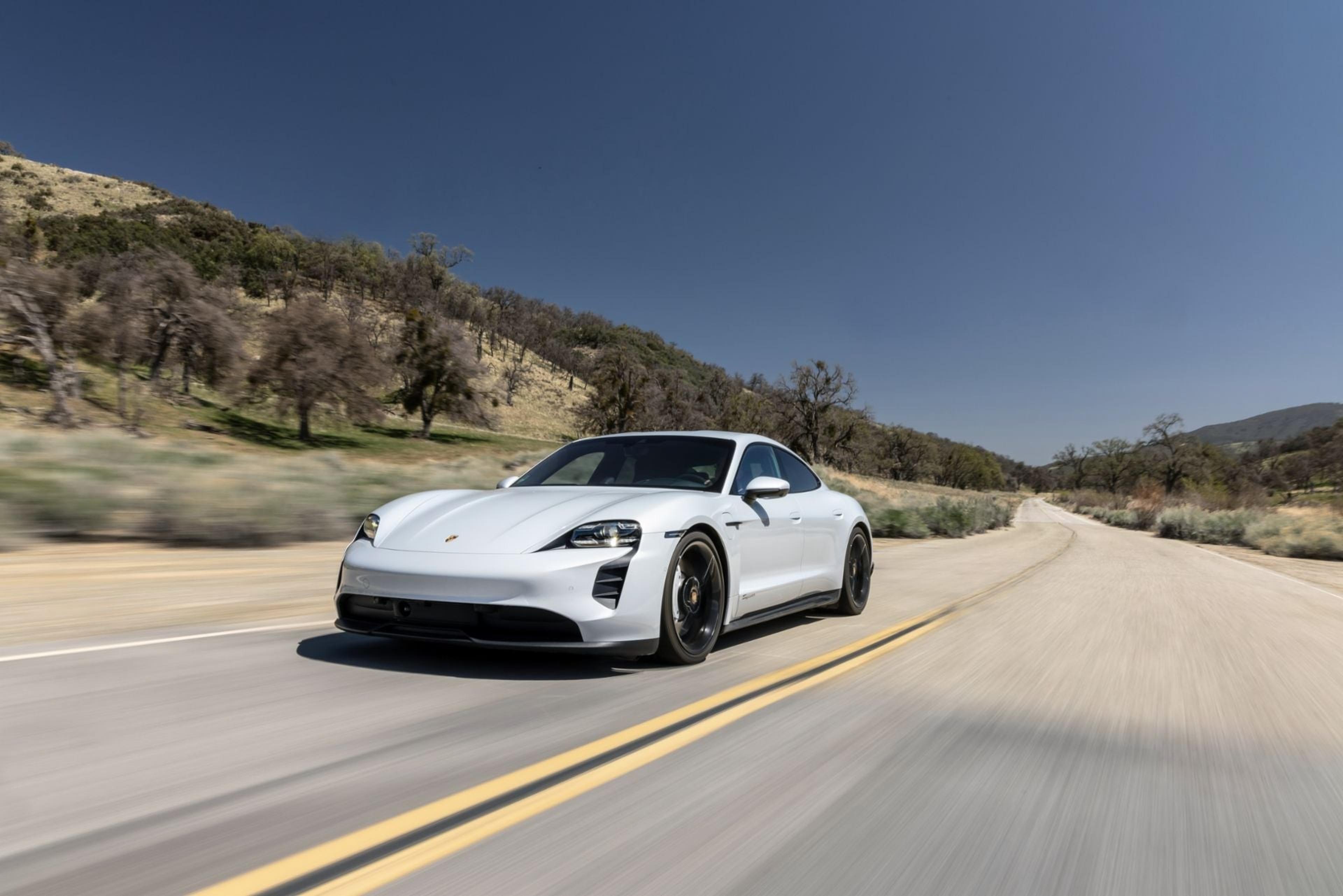 White Porsche Taycan driving on a mountain road