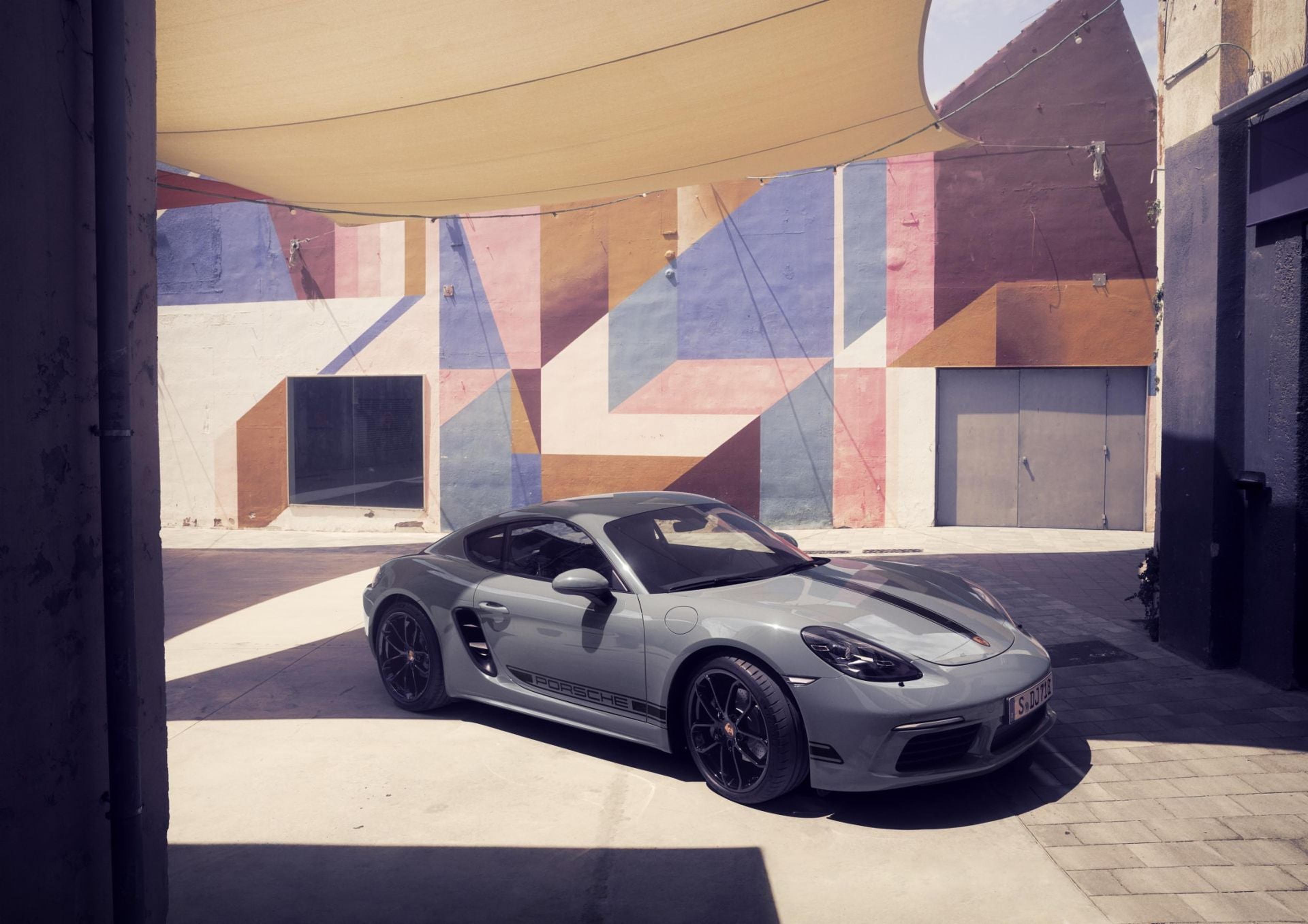 Gray Porsche 718 Cayman by a colorful wall