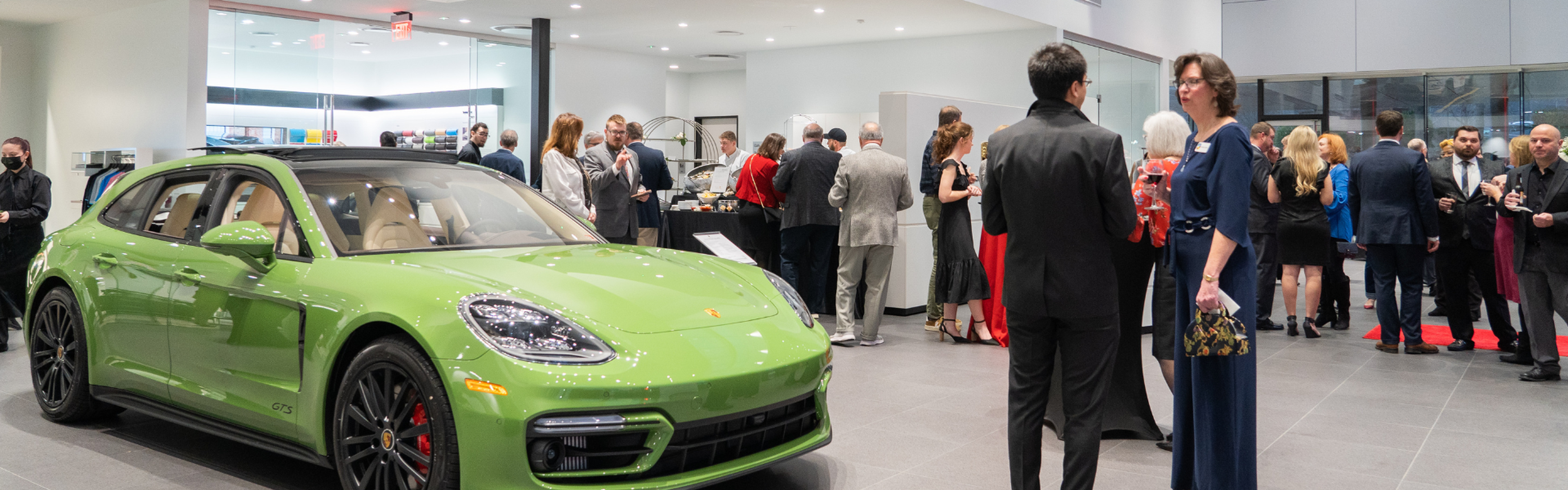 People gathered around the Porsche Charlottesville showroom for the dealership grand opening
