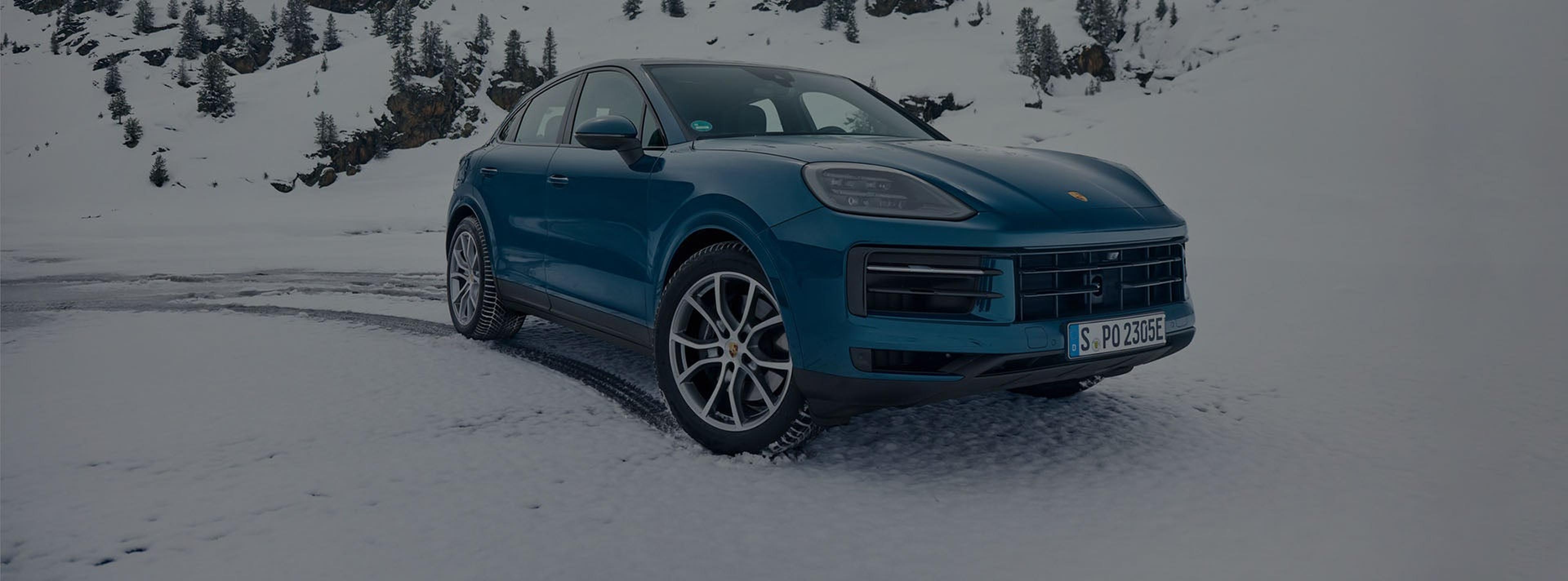 Porsche Cayenne on winter tires driving through snow