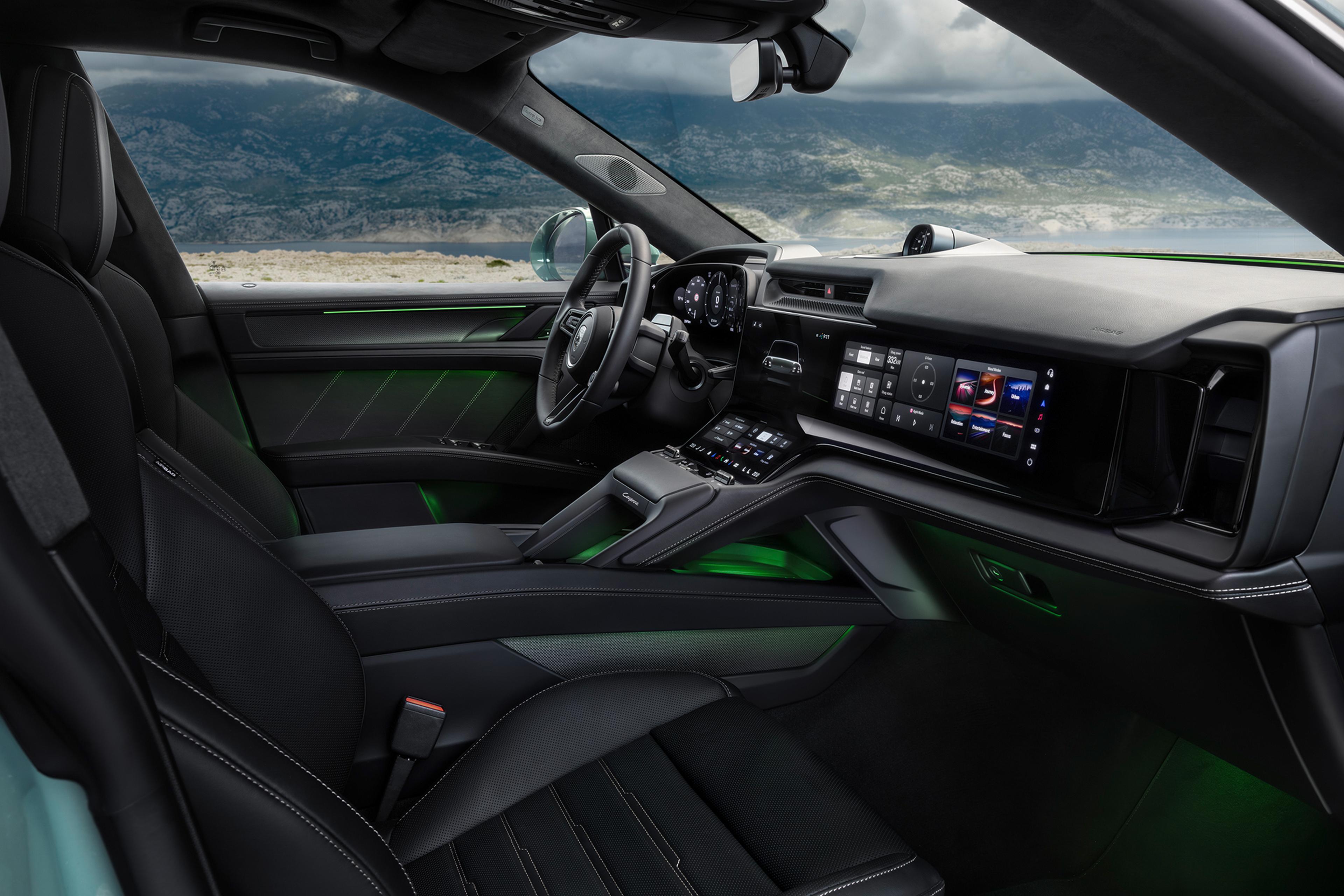 Innenraum eines Luxusautos mit schwarzen Ledersitzen, einem modernen Armaturenbrett und einem digitalen Display mit grüner Ambientebeleuchtung, vor einer malerischen Kulisse.