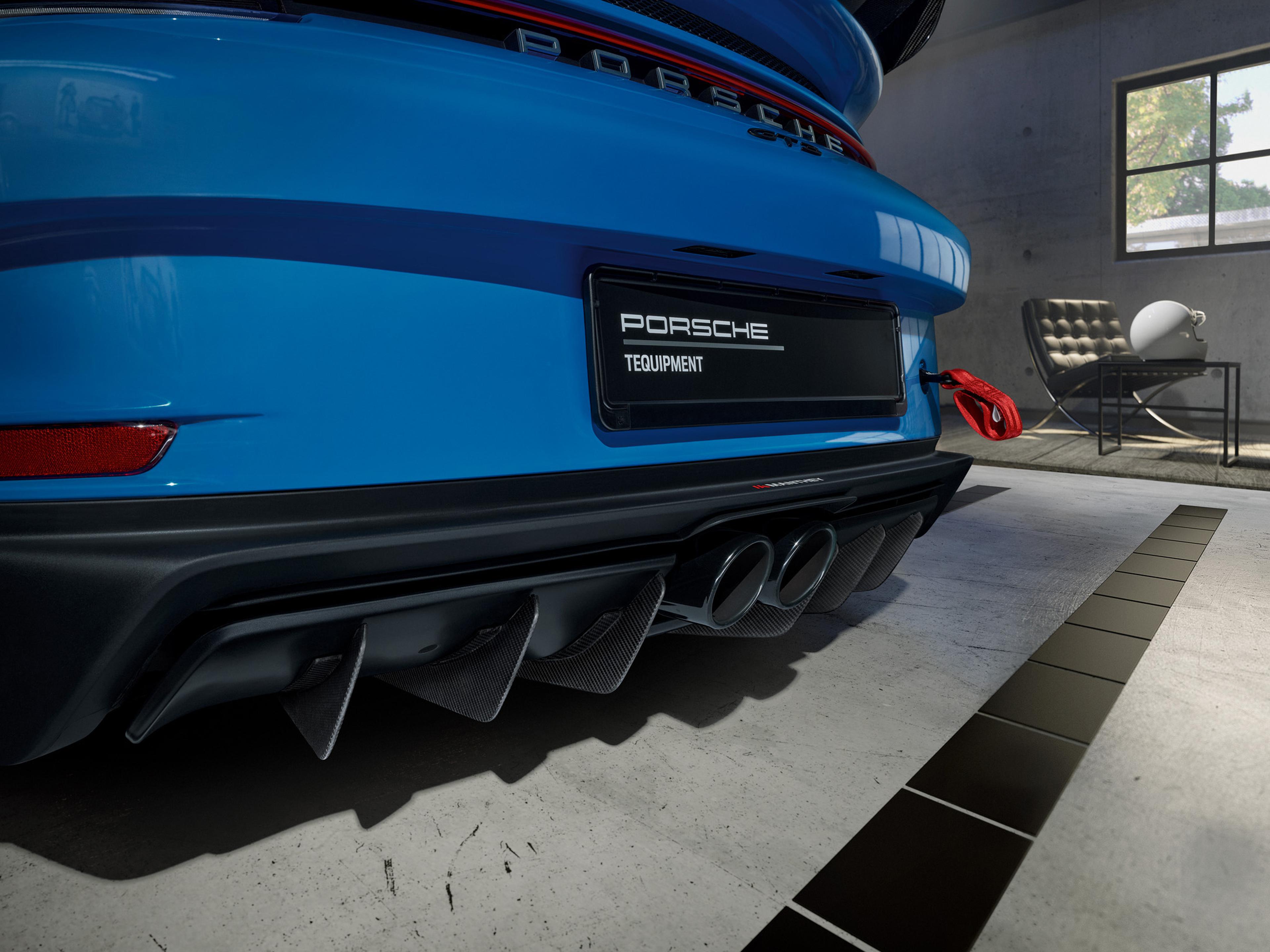 Close-up rear view of a Porsche 911 featuring a Manthey carbon-fiber rear diffuser, center-exit exhaust system, and track-focused aerodynamic upgrades.