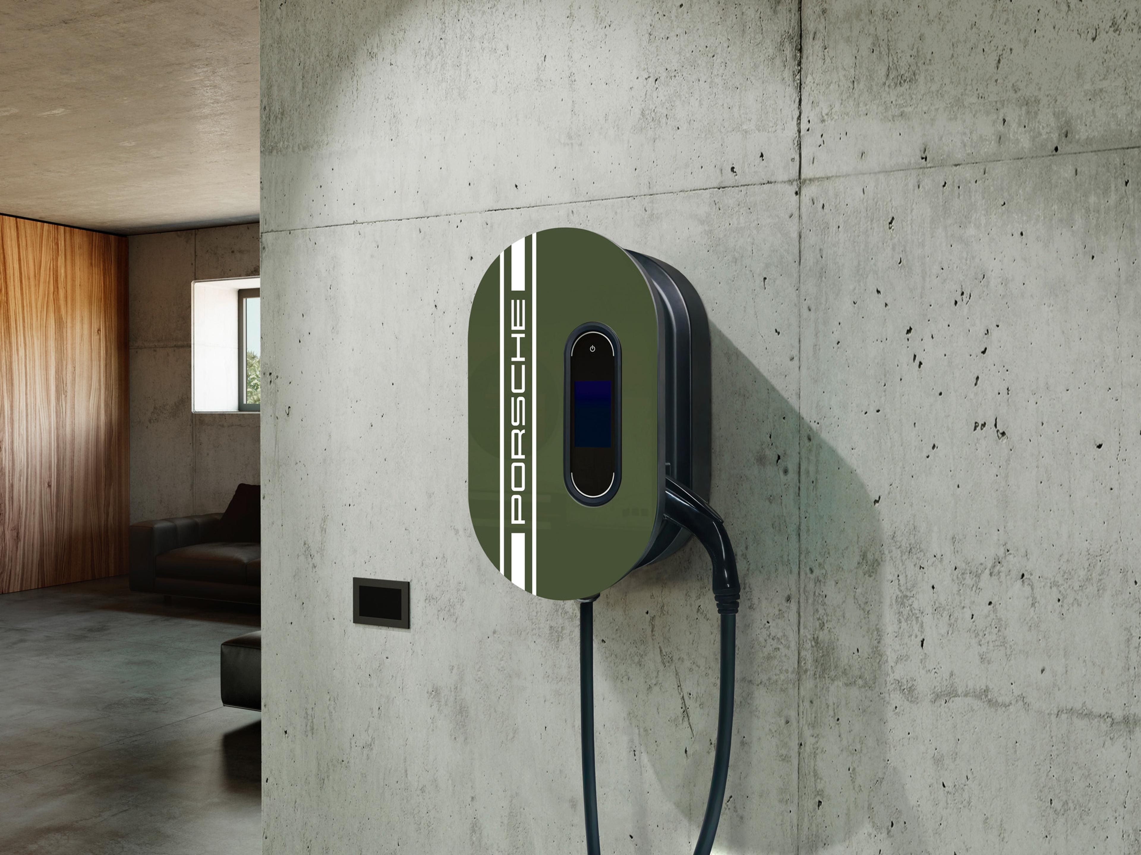 Green Porsche electric vehicle charger mounted on a concrete wall in a modern interior with wooden accents and a window.