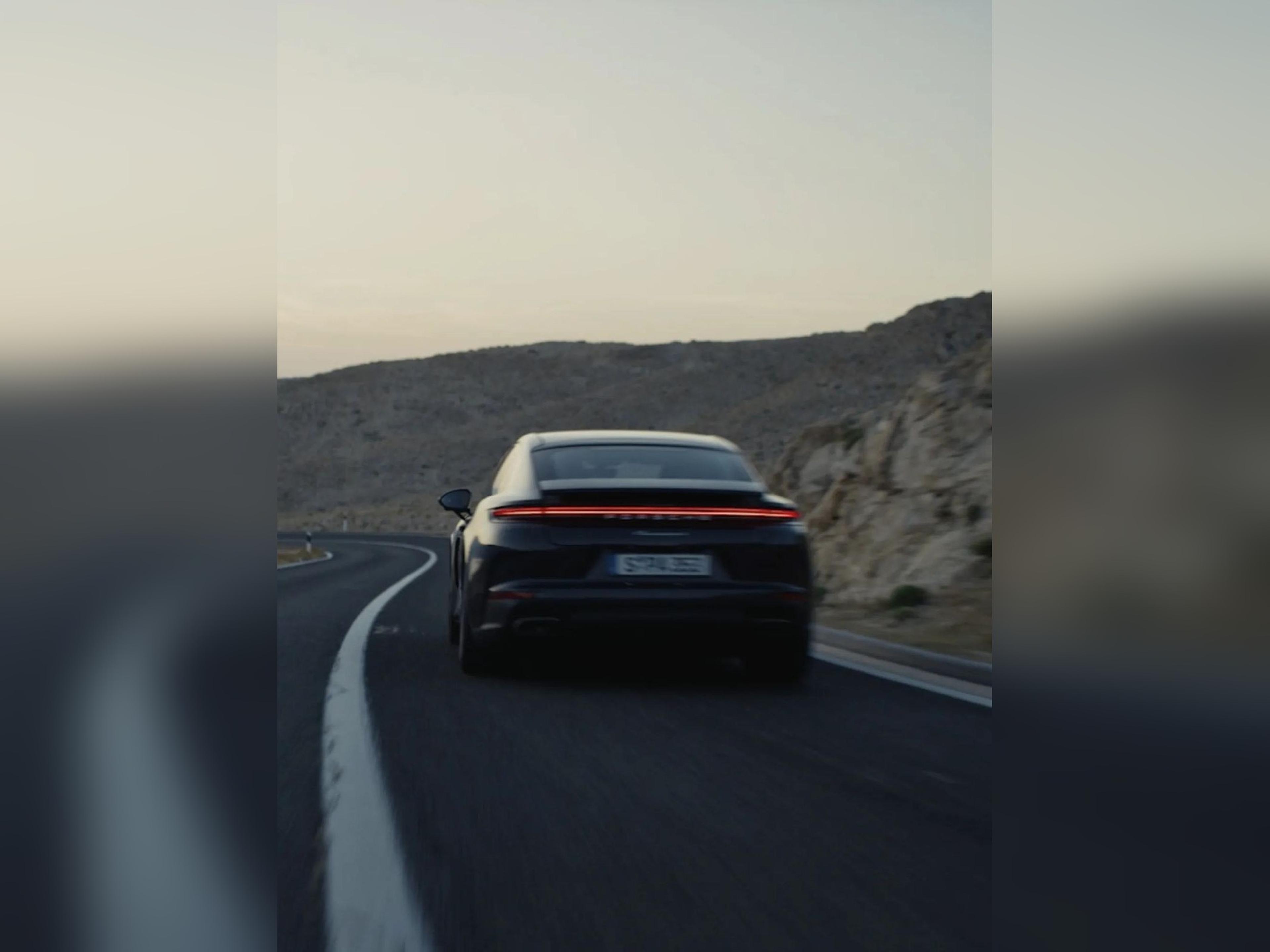 2026 Porsche Panamera rear view driving on an open road