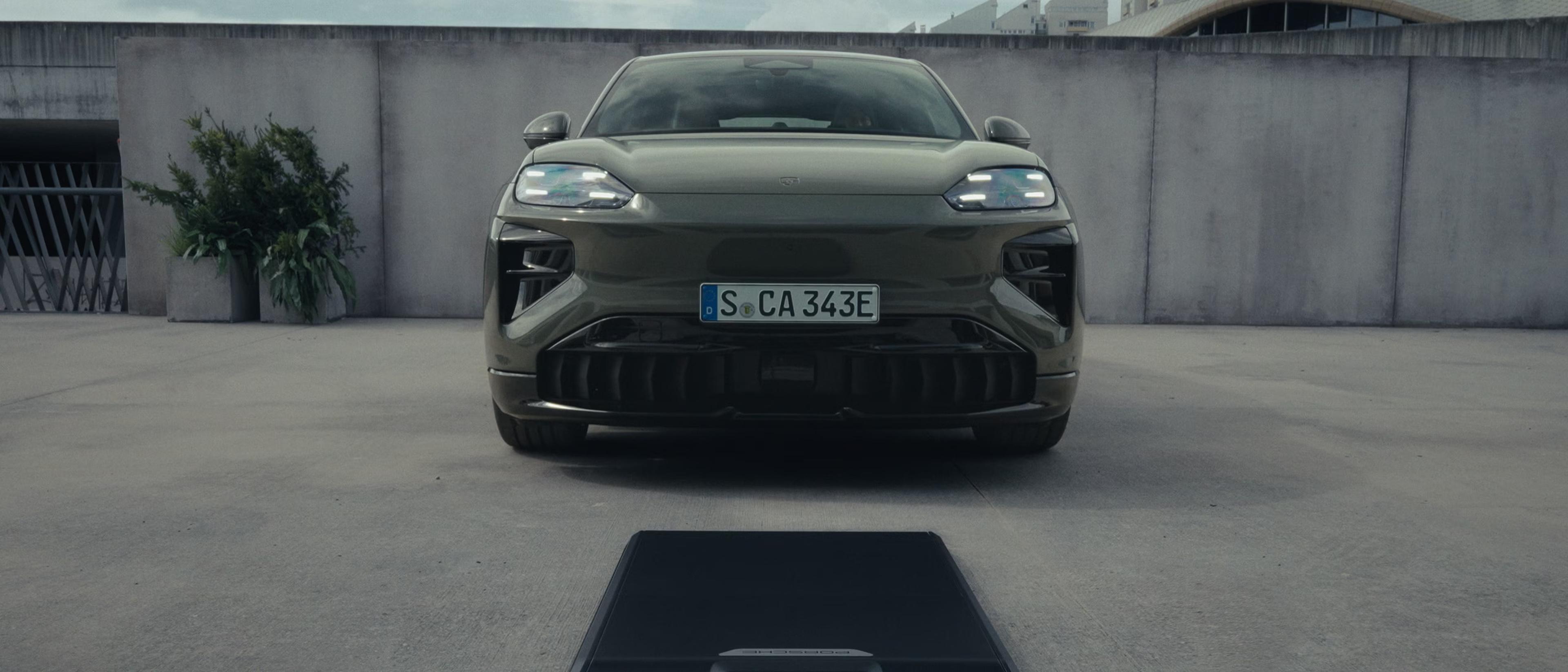 The 2027 Porsche Cayenne Coupe Electric parked outside in front of a charger