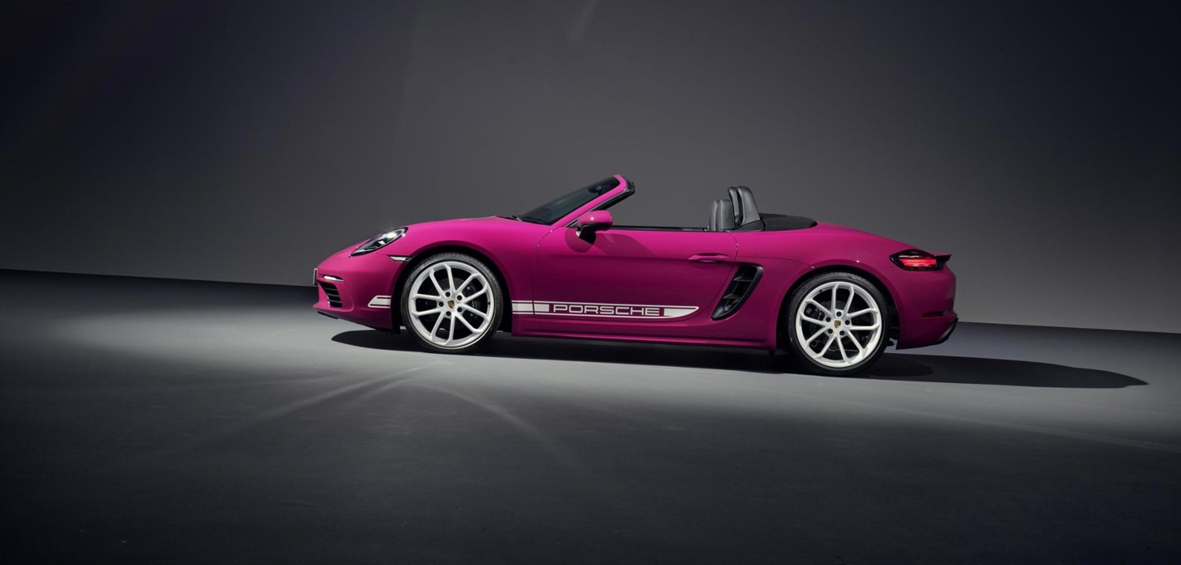 Magenta Porsche 718 Boxster convertible with the top down