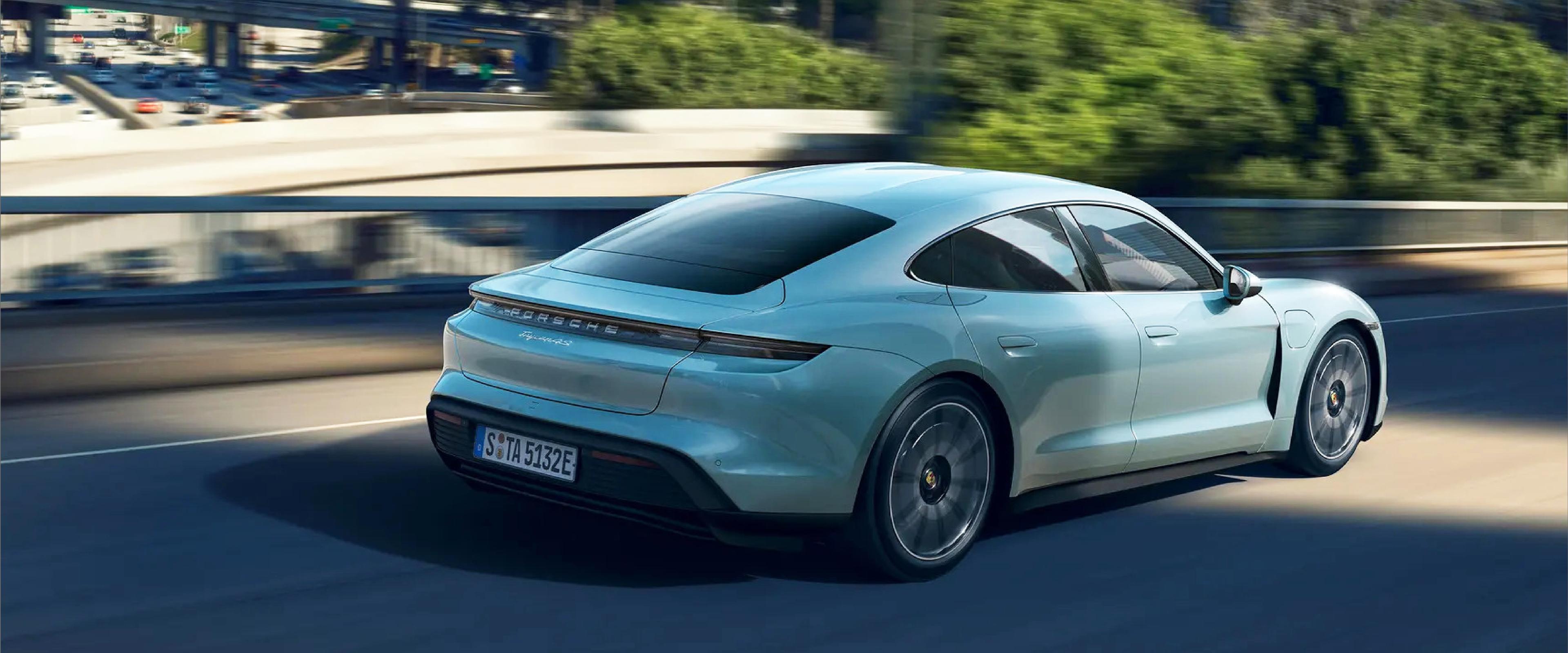 side_view_of_a_porsche_taycan_driving_down_paved_road