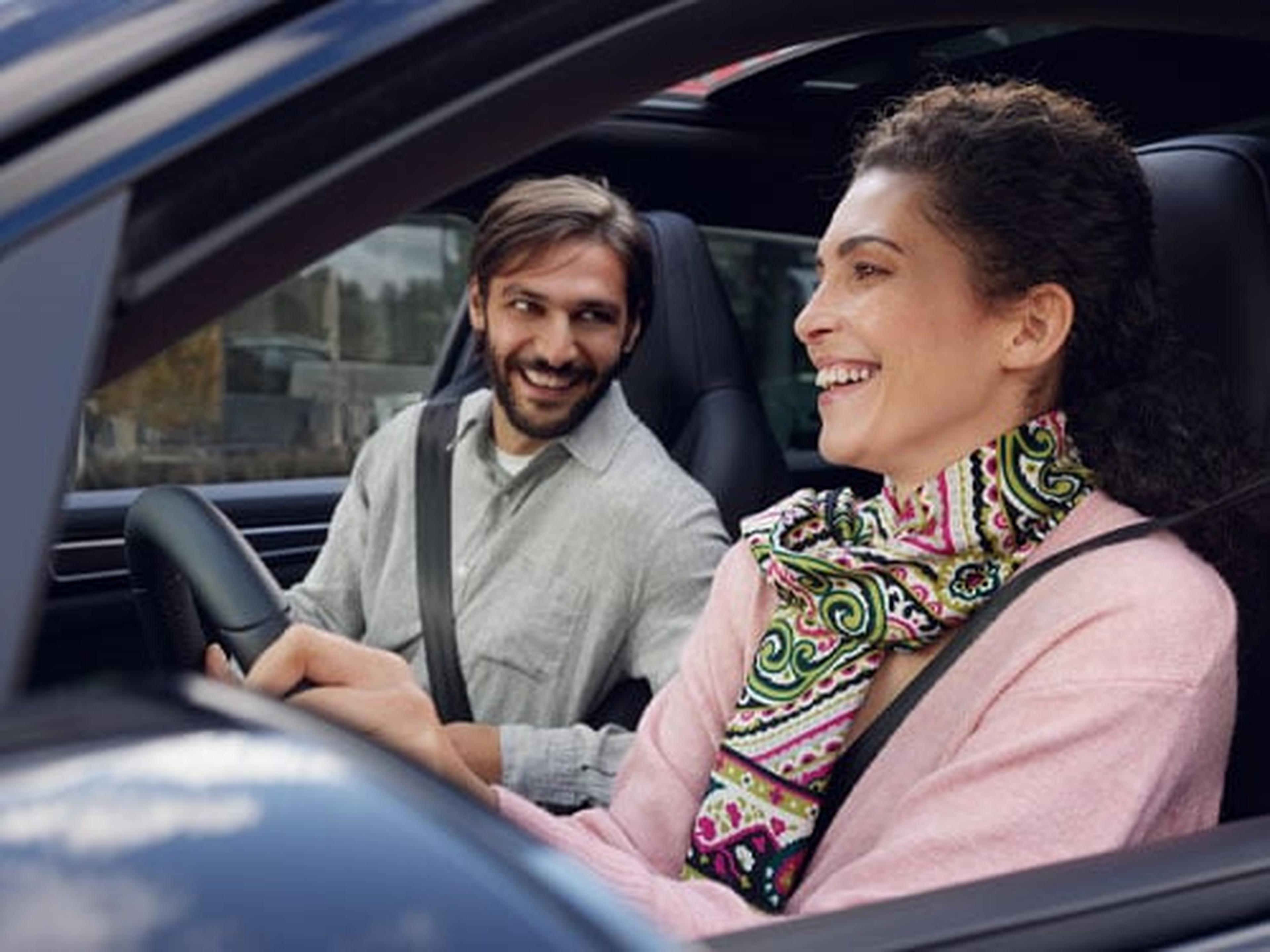 two customers laughing in a Porsche