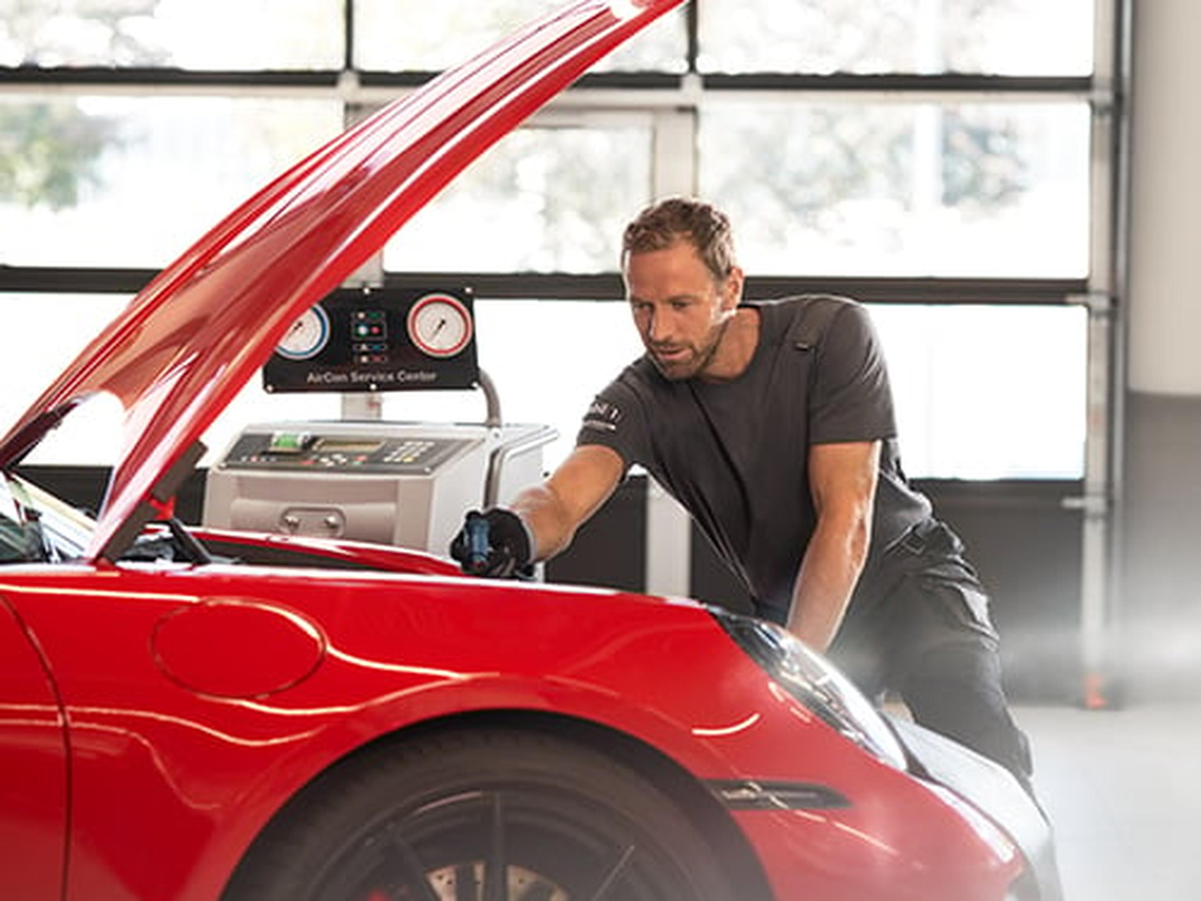 Mann prüft die Klimaanlage eines Autos in der Werkstatt.