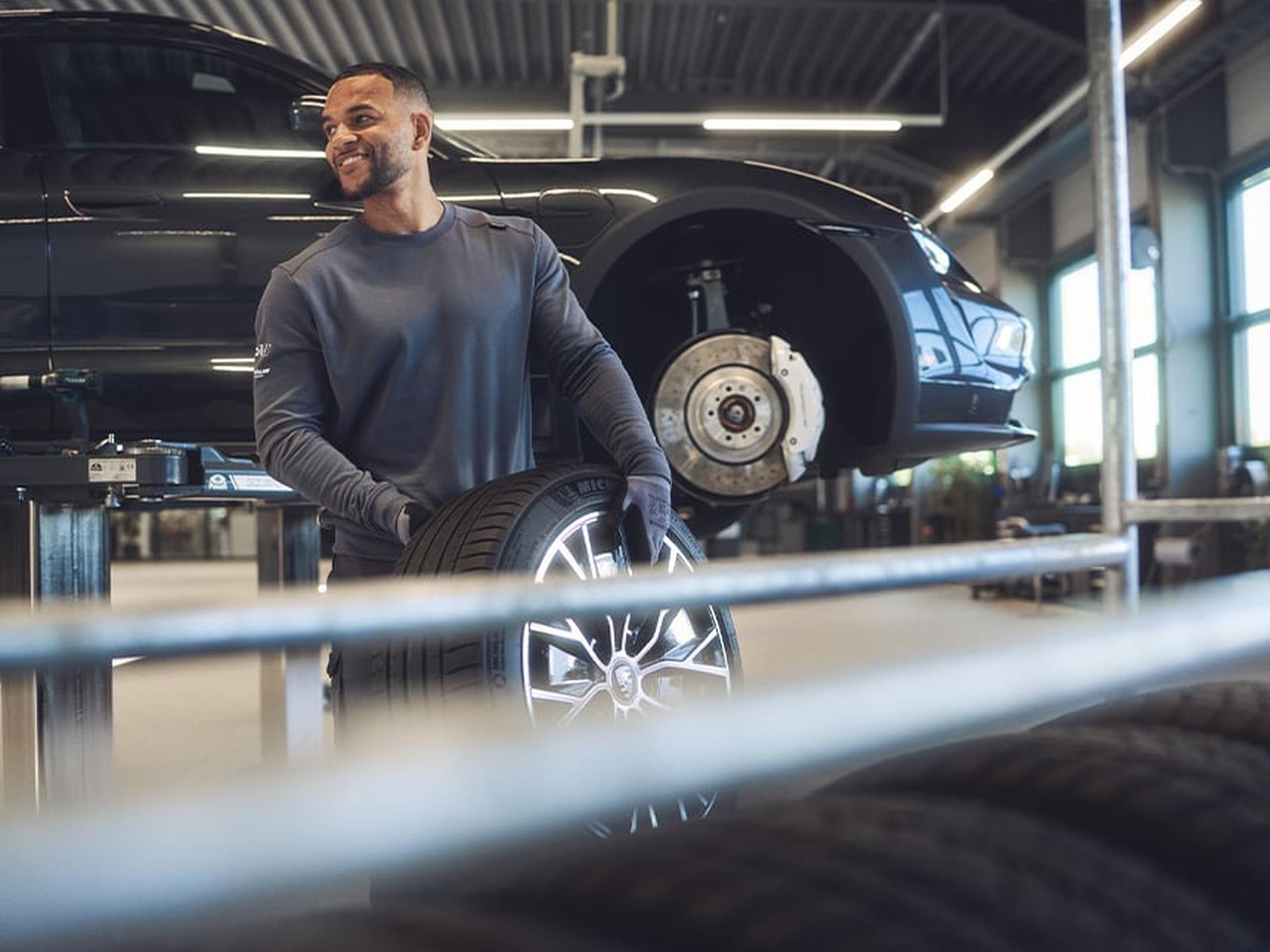 Ein Porsche Servicemitarbeiter wechselt einen Reifen aus.
