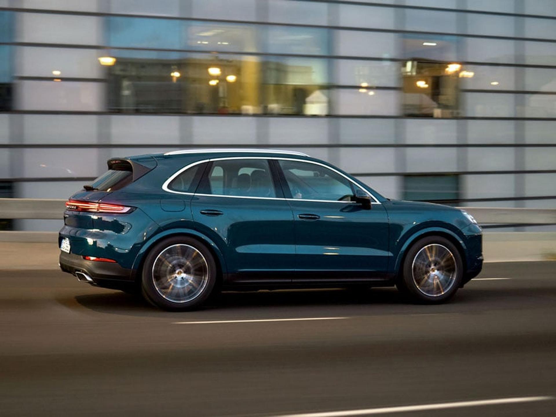 Blue Cayenne driving along highway.