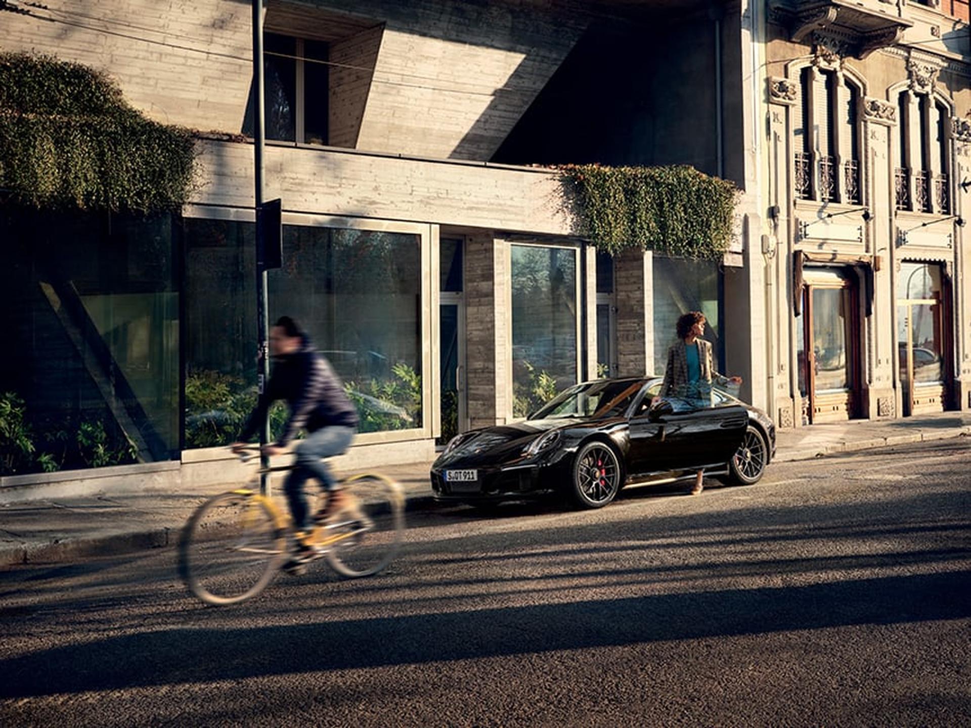 Eine Porsche Kundin steigt aus ihrem Porsche Sportwagen.