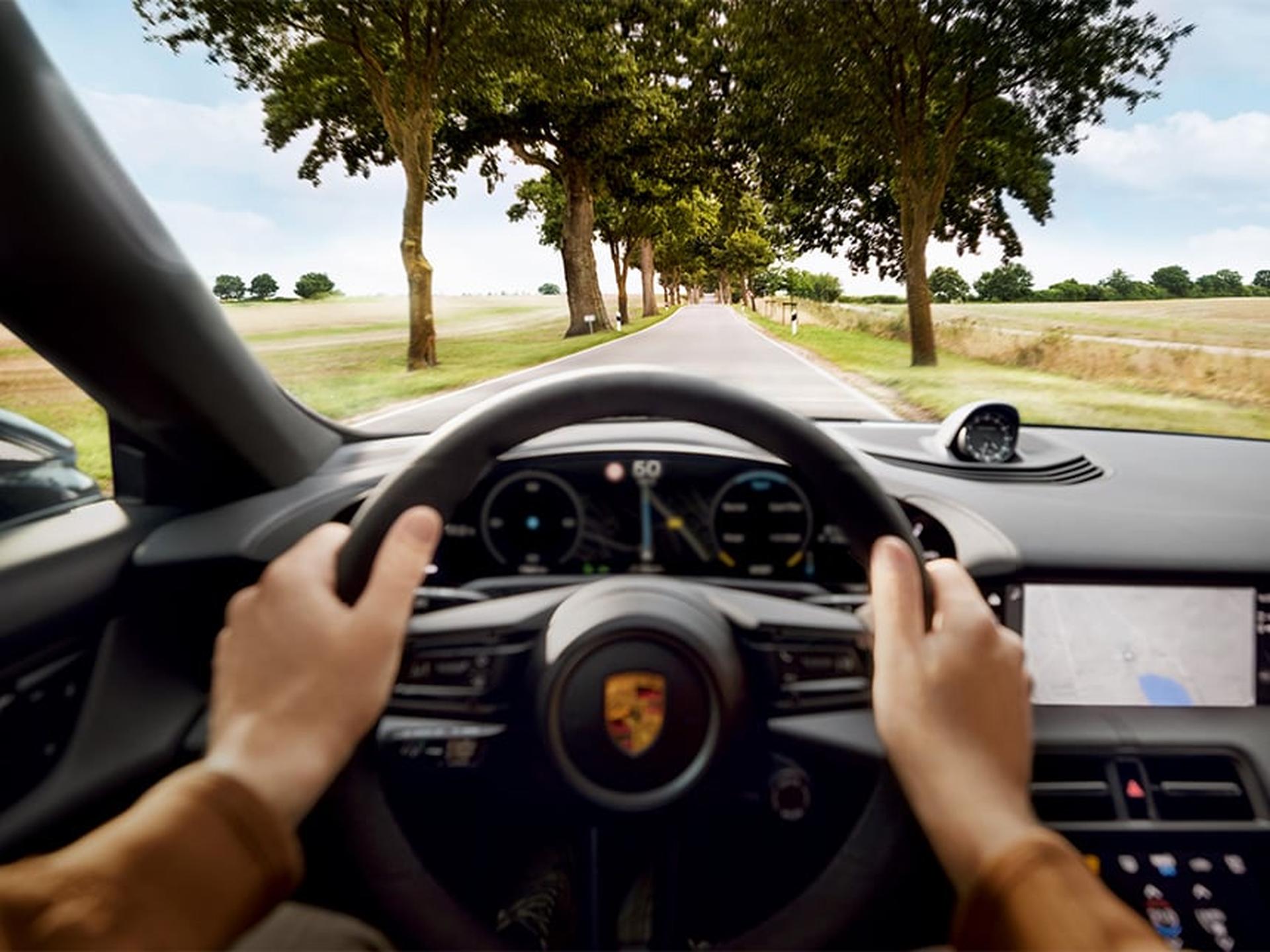 Ein Porsche Sportwagen fährt auf einer Landstraße.