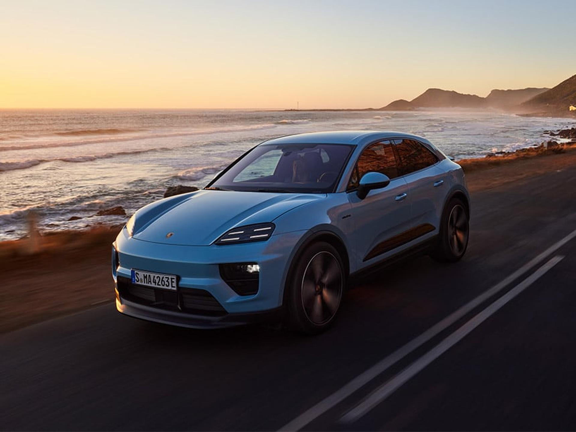 Ein Porsche Sportwagen fährt auf einer Strasse am Strand entlang.