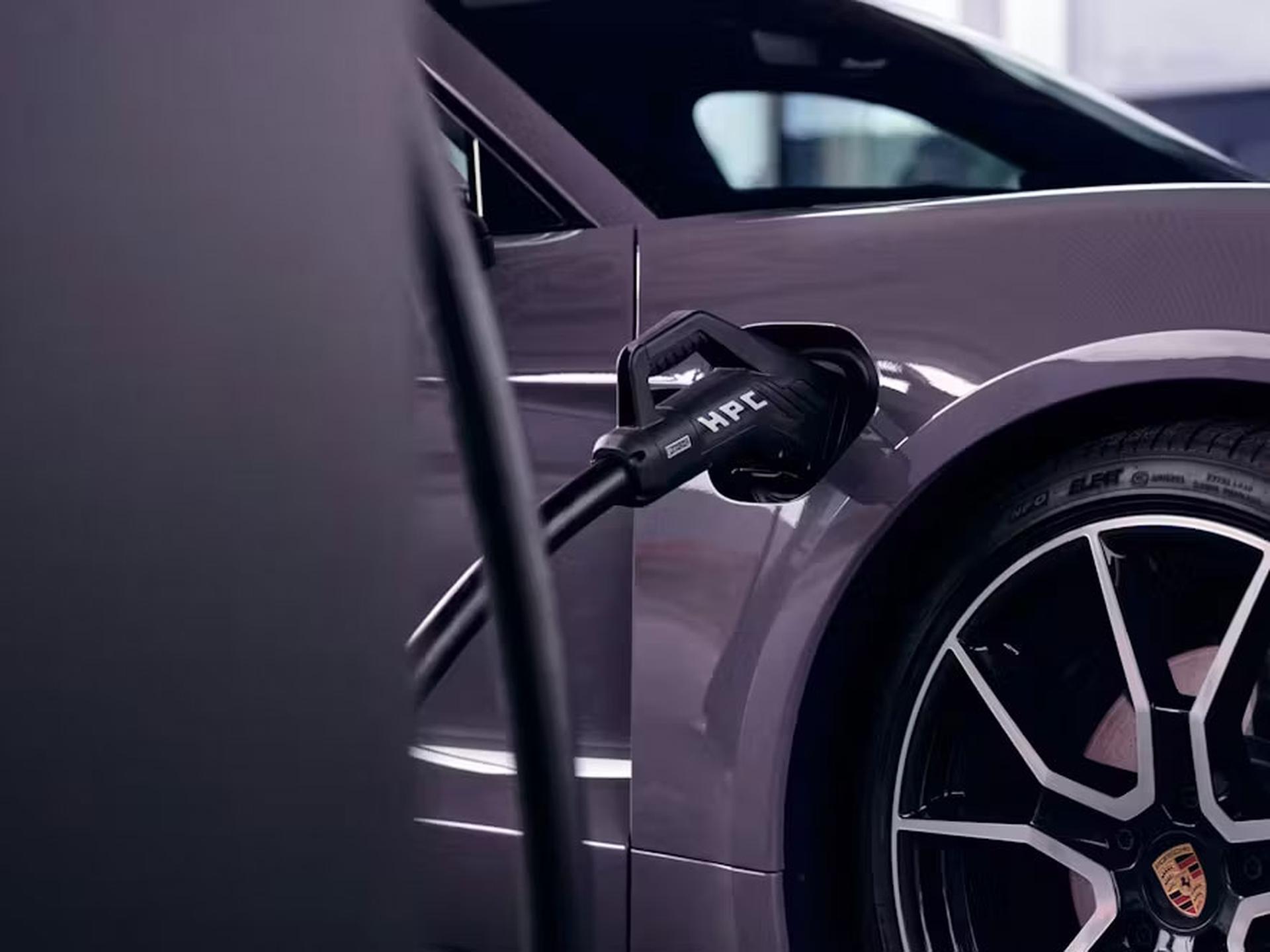 Eine Nahaufnahme eines violetten Elektroautos, das mit einem HPC-Ladekabel geladen wird; zu sehen sind der Hinterreifen und das Felgendesign.
