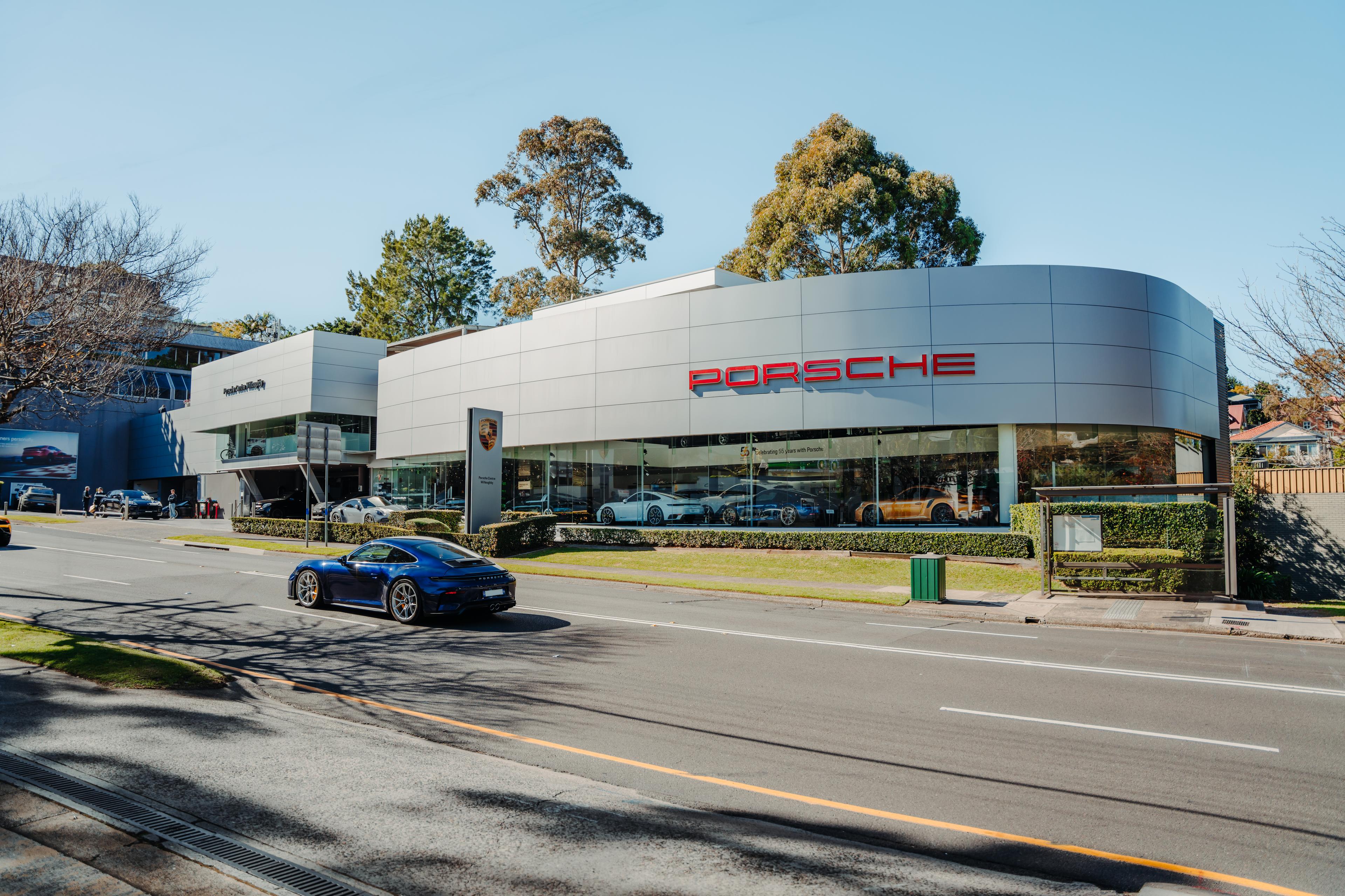 Exterior view of Porsche Centre Willoughby, showcasing the dealership’s modern architectural design, glass façade and Porsche branding.