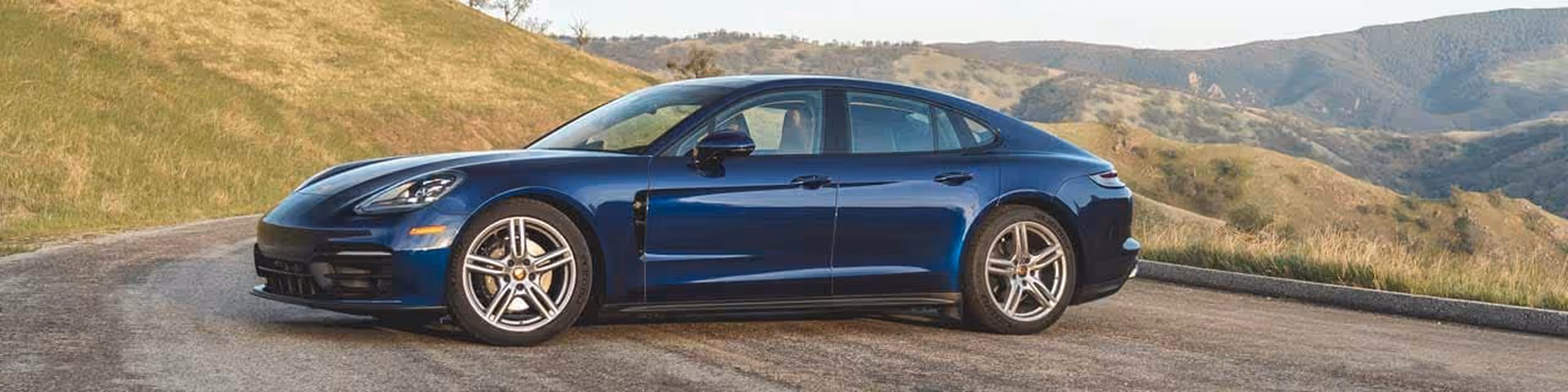 Blue 2024 Porsche Panamera parked in the wilderness