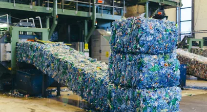 "Compressed plastic waste bales in recycling facility, supporting Scott Bader's sustainable composites and resins production" [G]