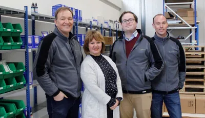 "Team members in a Scott Bader warehouse facility with storage shelves containing composite materials and supplies" [G]
