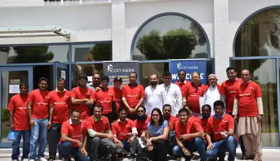 "Scott Bader team in red shirts gathered outside Dubai Blood Donation Centre, supporting community healthcare initiatives" [G]