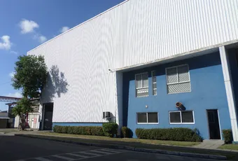 Industrial facility with white corrugated metal exterior and blue office section, potential Scott Bader manufacturing site [G]