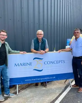 "Team at Marine Concepts event with industrial building backdrop, showcasing marine applications for composites" [G]