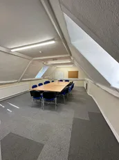 Attic-style meeting room with conference table and chairs at a Scott Bader office location. [G]