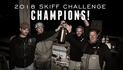 "2018 Skiff Challenge Champions celebrating victory with trophy at night event, supported by Scott Bader composites" [G]