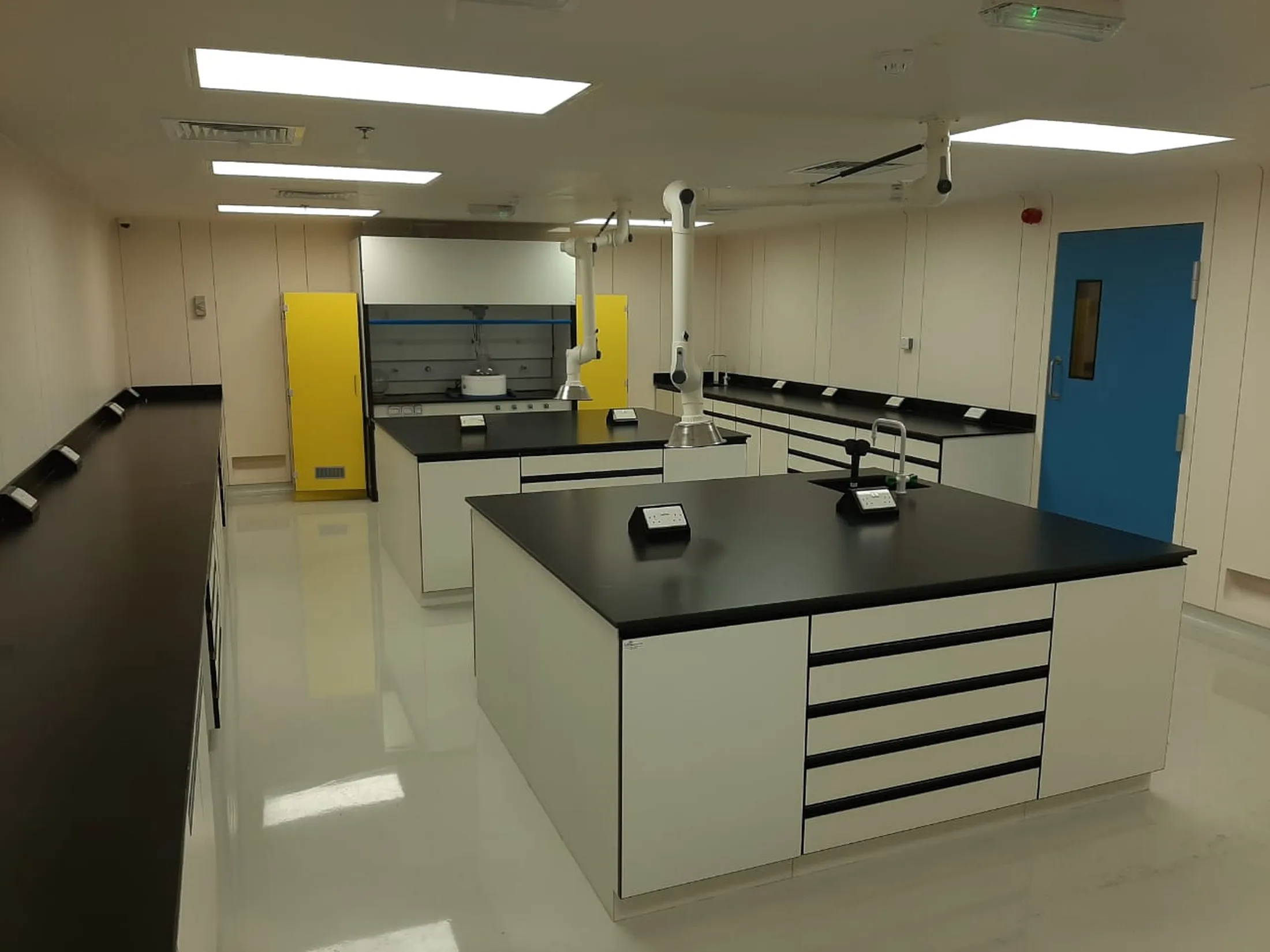 "Modern laboratory workspace with black countertops and white cabinetry, designed for testing Scott Bader resins and composites" [G]