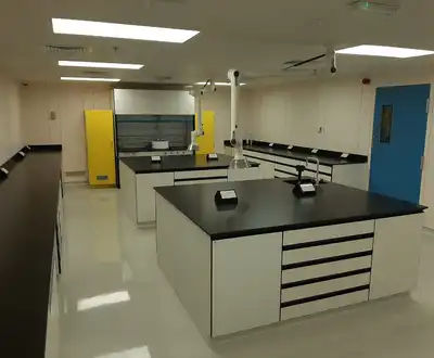 "Modern laboratory workspace with black countertops and white cabinetry, designed for testing Scott Bader resins and composites" [G]